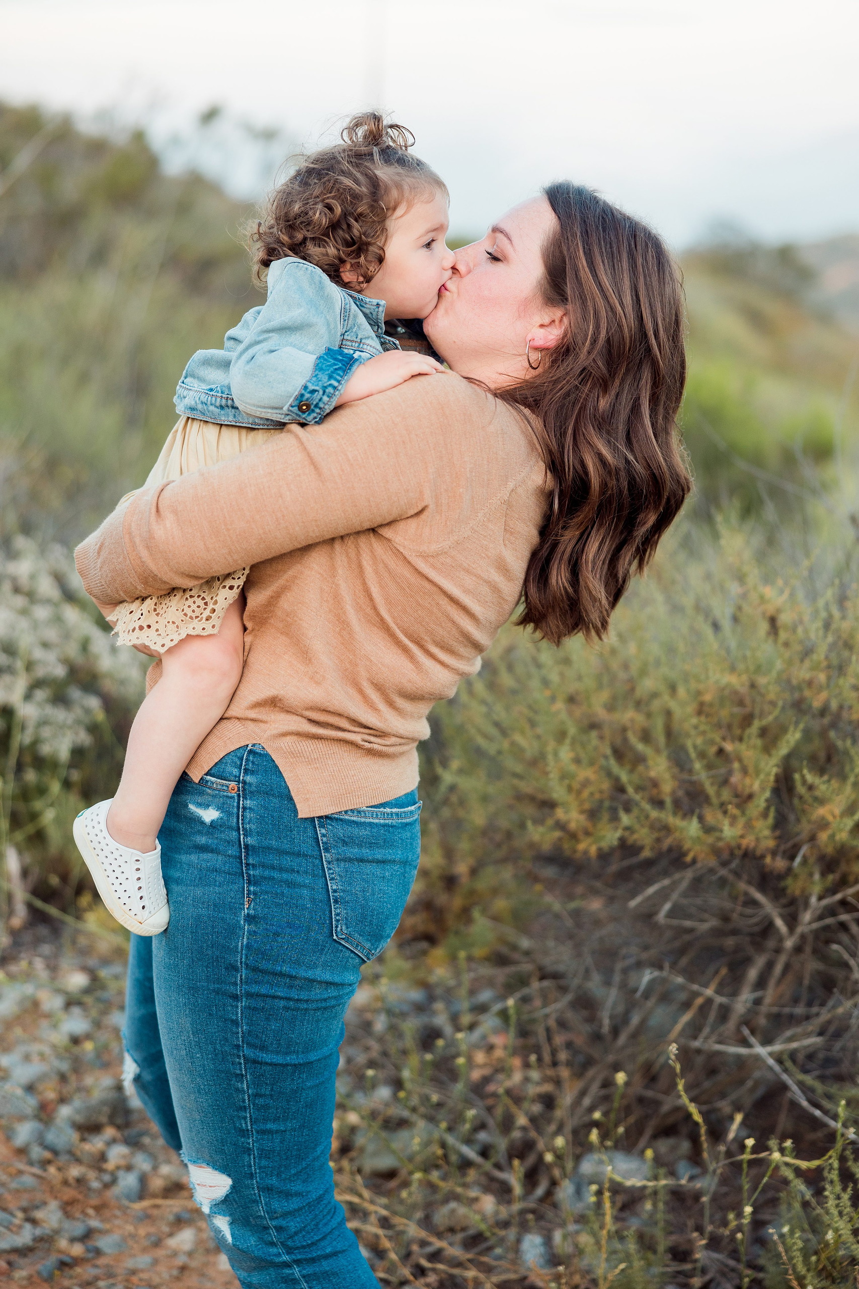 Dictionary Hill Nature Trails Family Photography in San Diego — 52 Woman kissing toddler in her arms on Dictionary Hill Nature Trails