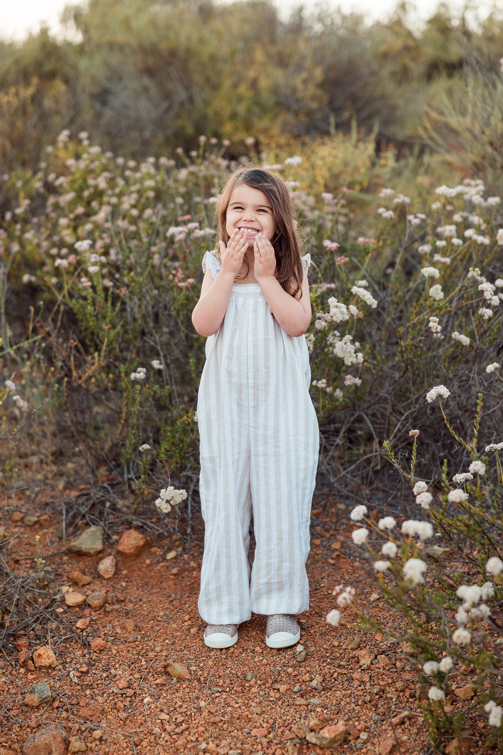 Dictionary Hill Nature Trails Family Photography in San Diego — 54 Older child smiling among white flowering shrubs at Dictionary Hill