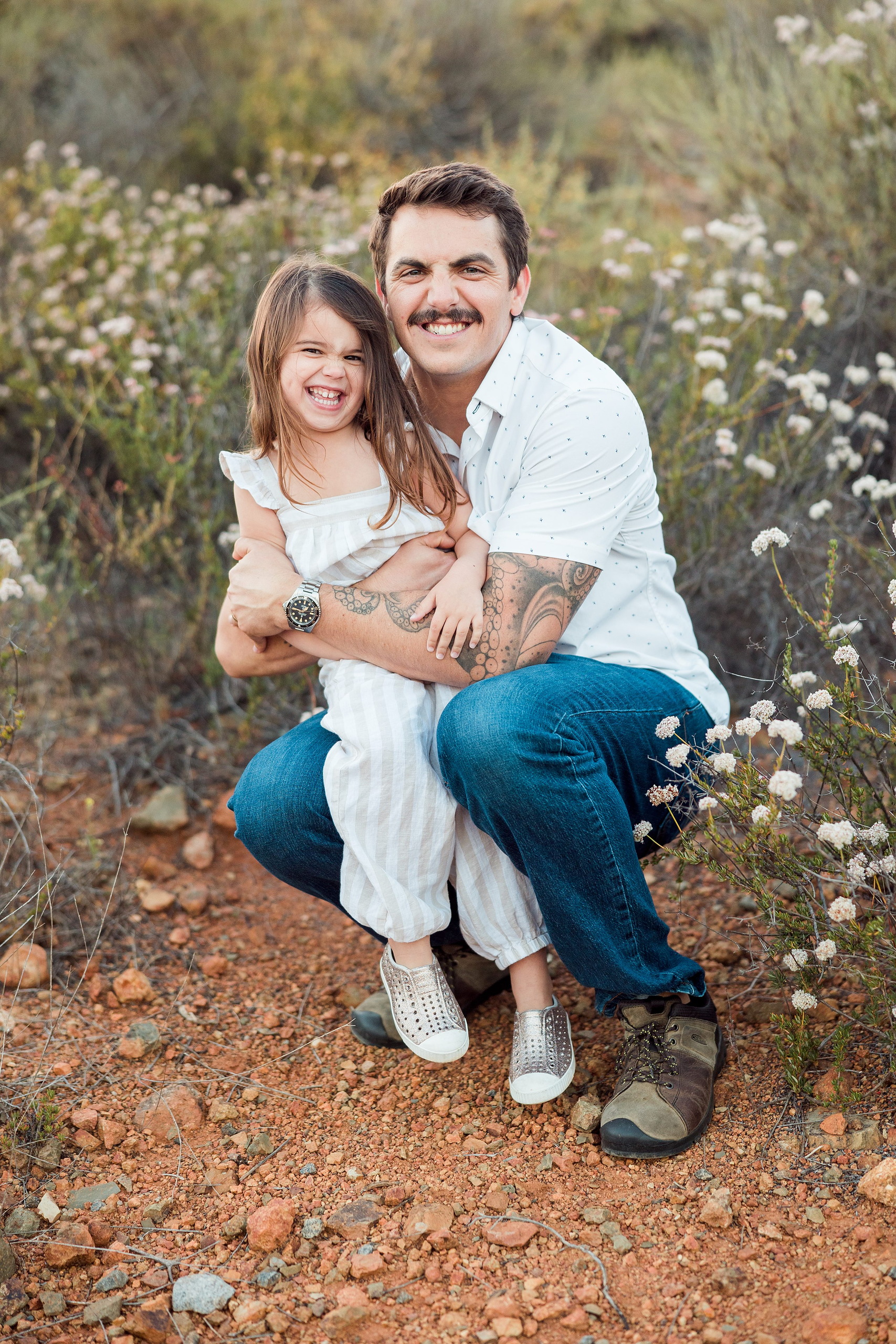 Dictionary Hill Nature Trails Family Photography in San Diego — 56 Father with child crouching among white flowers at Dictionary Hill