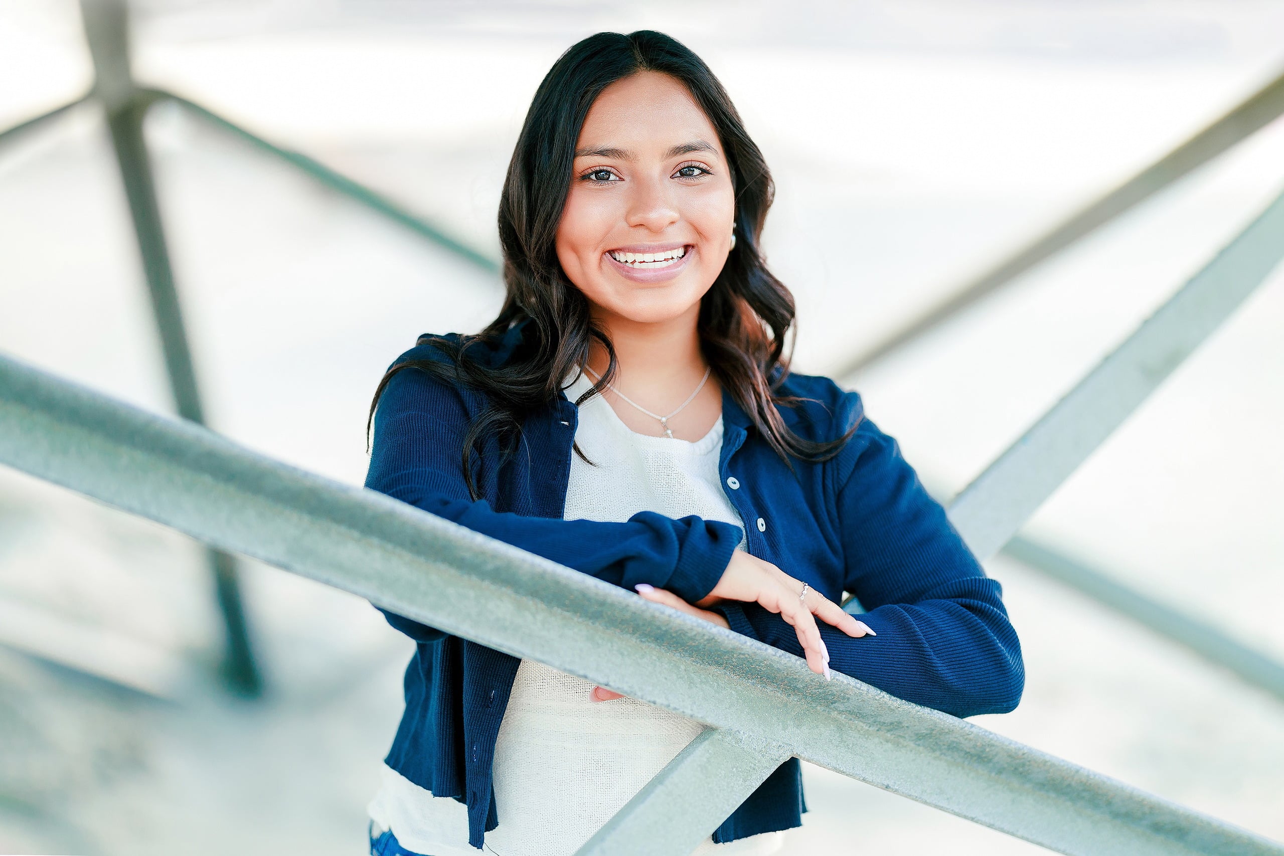 Evanna, Atalia, and Erleen’s Senior Session on Coronado — 14 Senior in white top and navy cardigan leaning on pier at Coronado
