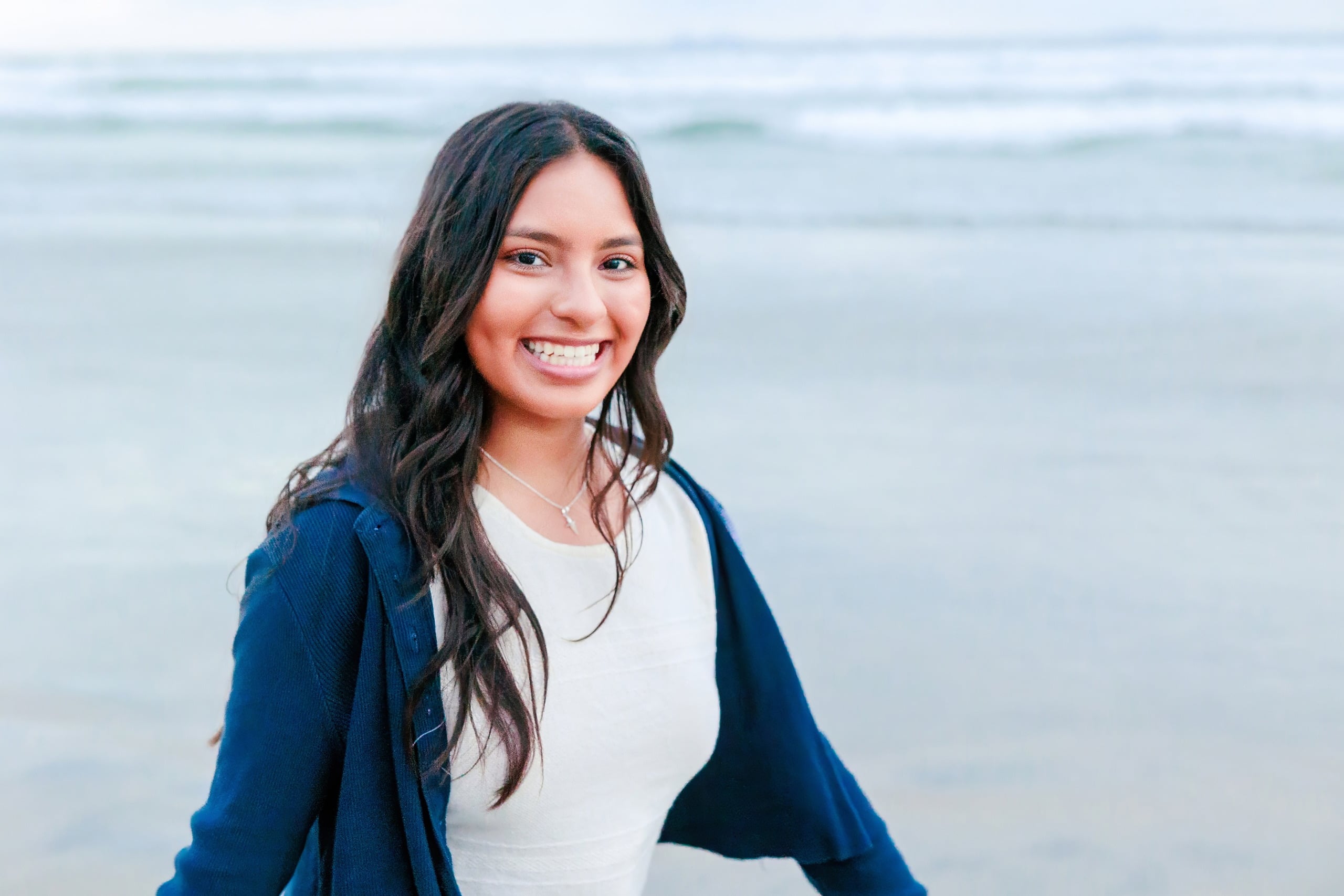 Evanna, Atalia, and Erleen’s Senior Session on Coronado — 28 Senior in navy cardigan smiling by ocean at Coronado beach shore