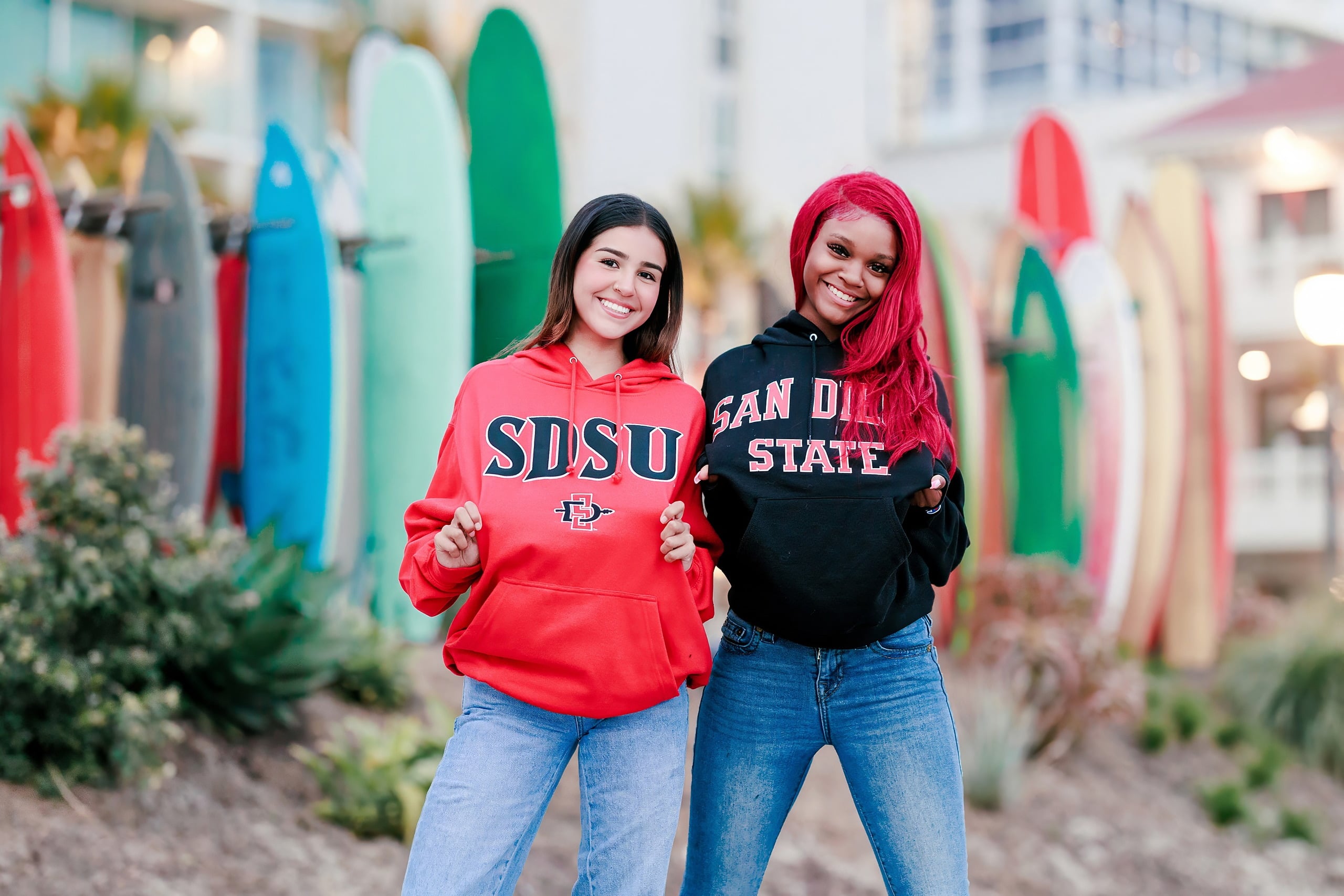 Evanna, Atalia, and Erleen’s Senior Session on Coronado — 39 Two seniors in college hoodies by colorful surfboards at beach