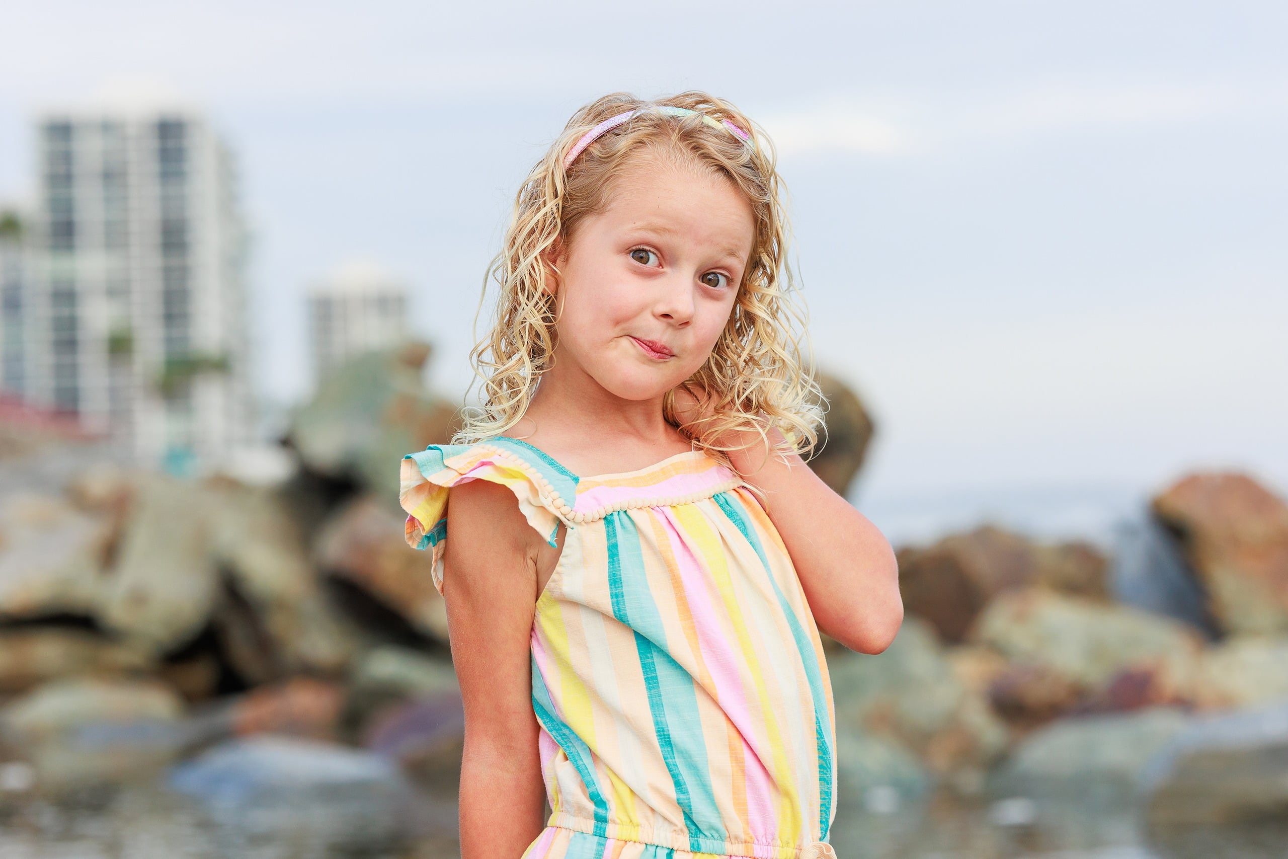 Extended Family Photography Hotel Del Coronado — 13 Child in colorful striped dress, close-up portrait on rocky shore