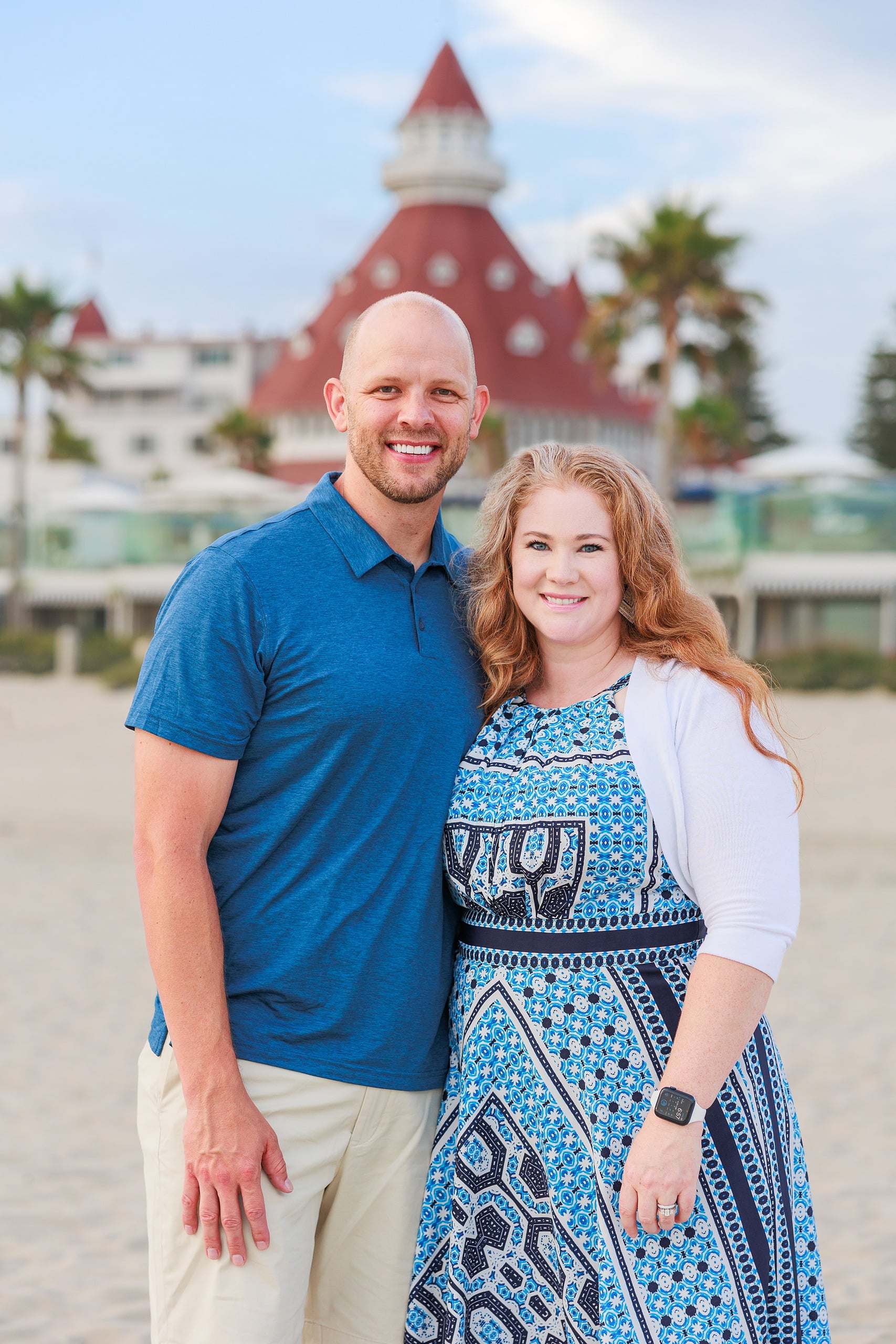 Extended Family Photography Hotel Del Coronado — 14 Man and woman stand close on sandy beach, Hotel del Coronado across the water
