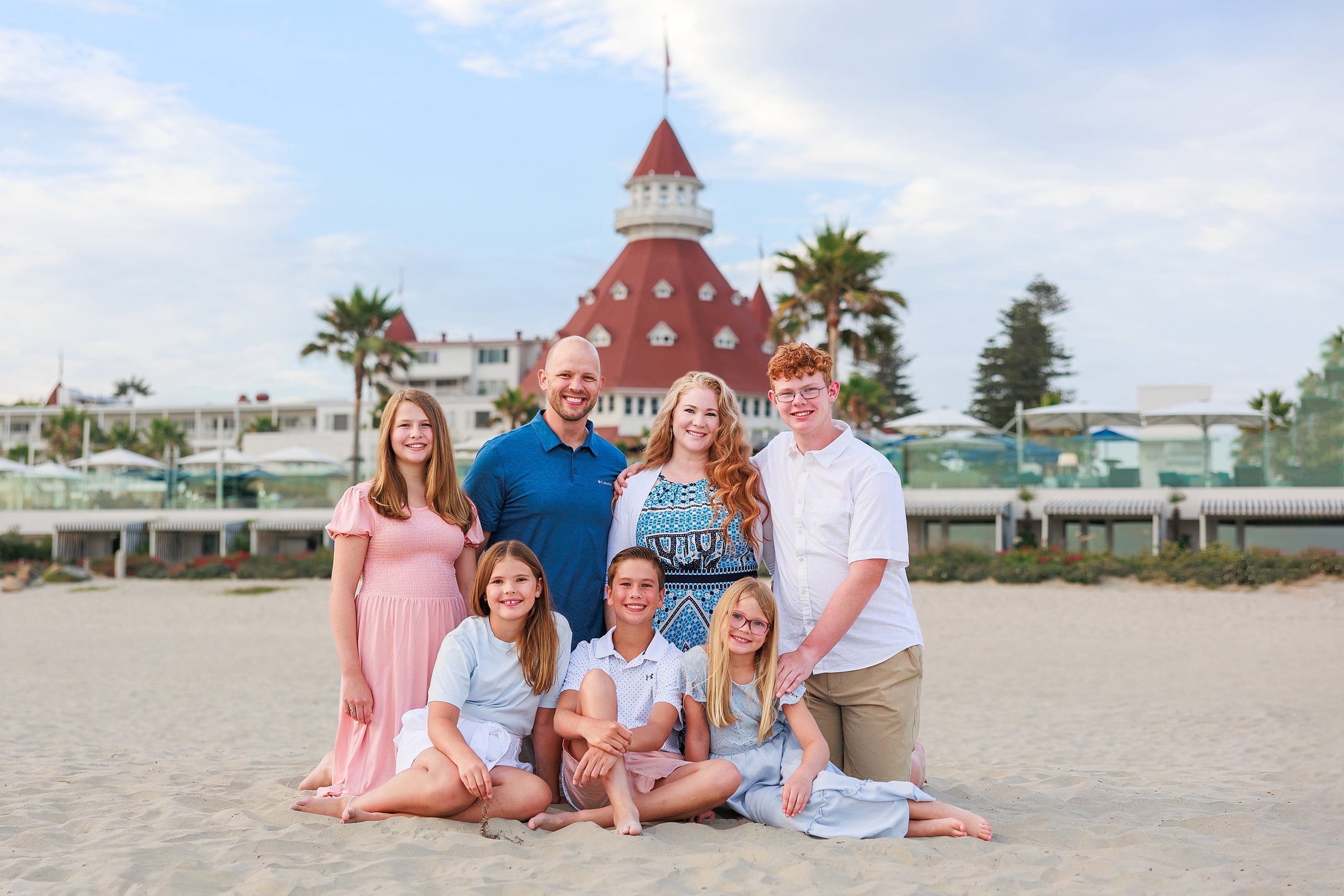 Extended Family Photography Hotel Del Coronado — 23 Family group arranged on sand smiling toward camera, Hotel del Coronado behind