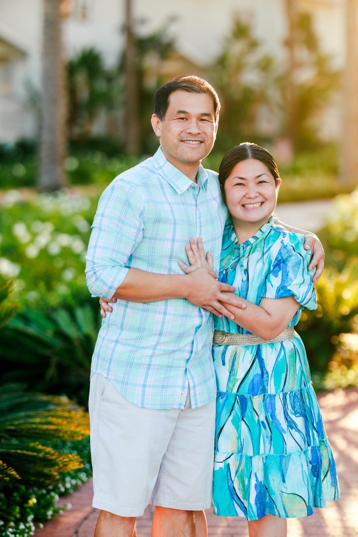 Couple embracing in lush garden at Hotel Del Coronado, San Diego family photographer session