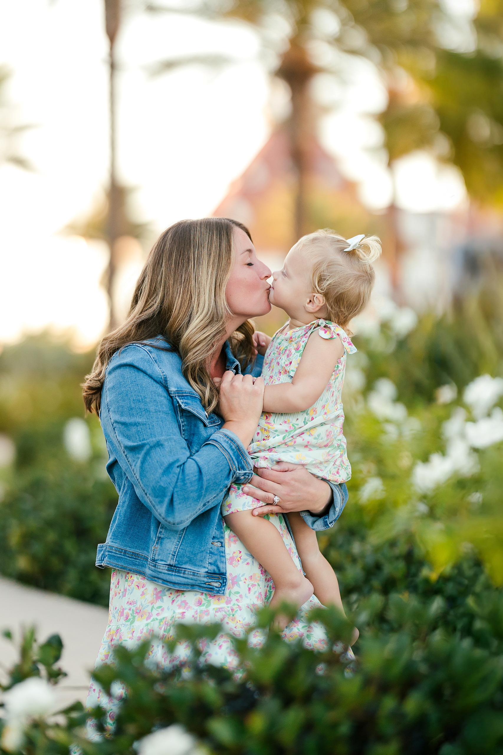 Hotel del Coronado Family Photos — 02 Mother kissing her toddler tenderly at Hotel del Coronado with palms