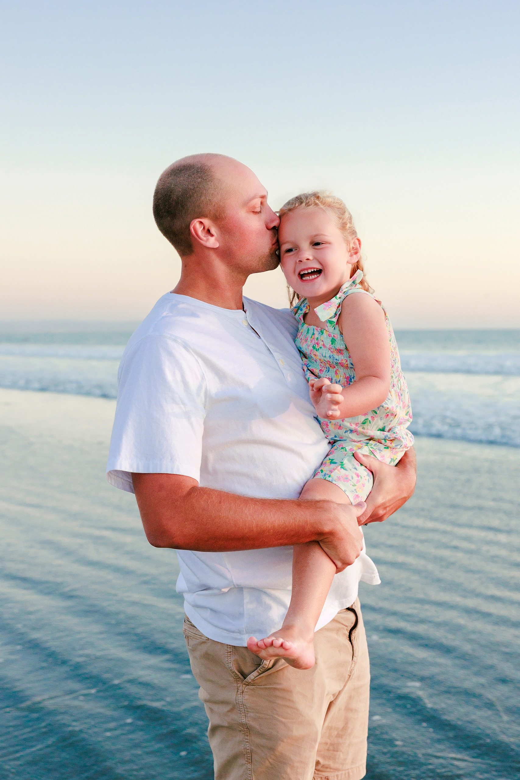 Hotel del Coronado Family Photos — 20 Father holding Poppy on the beach while smiling at golden hour
