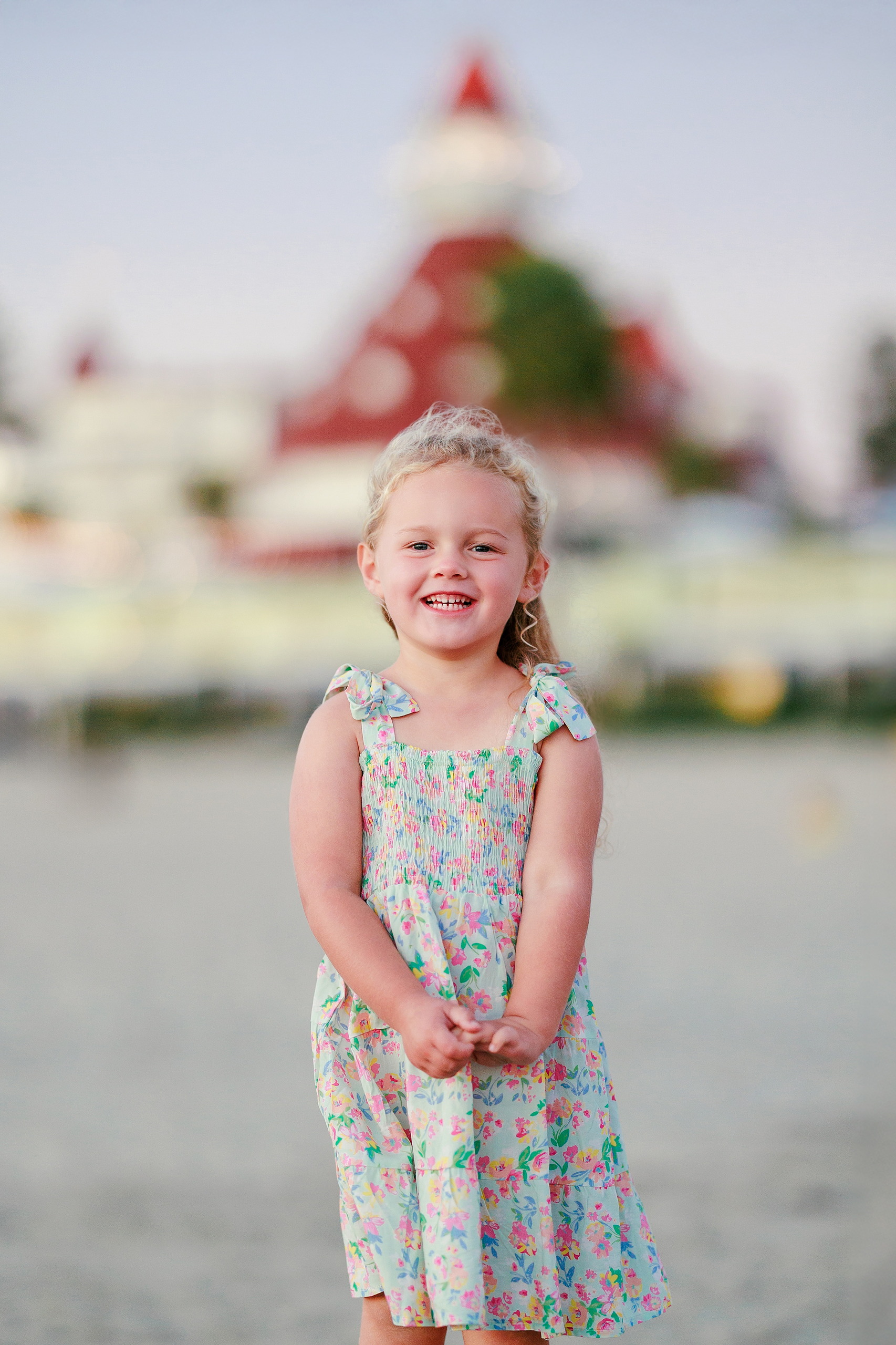Hotel del Coronado Family Photos — 23 Mabel smiling on the beach with Hotel del Coronado silhouetted behind