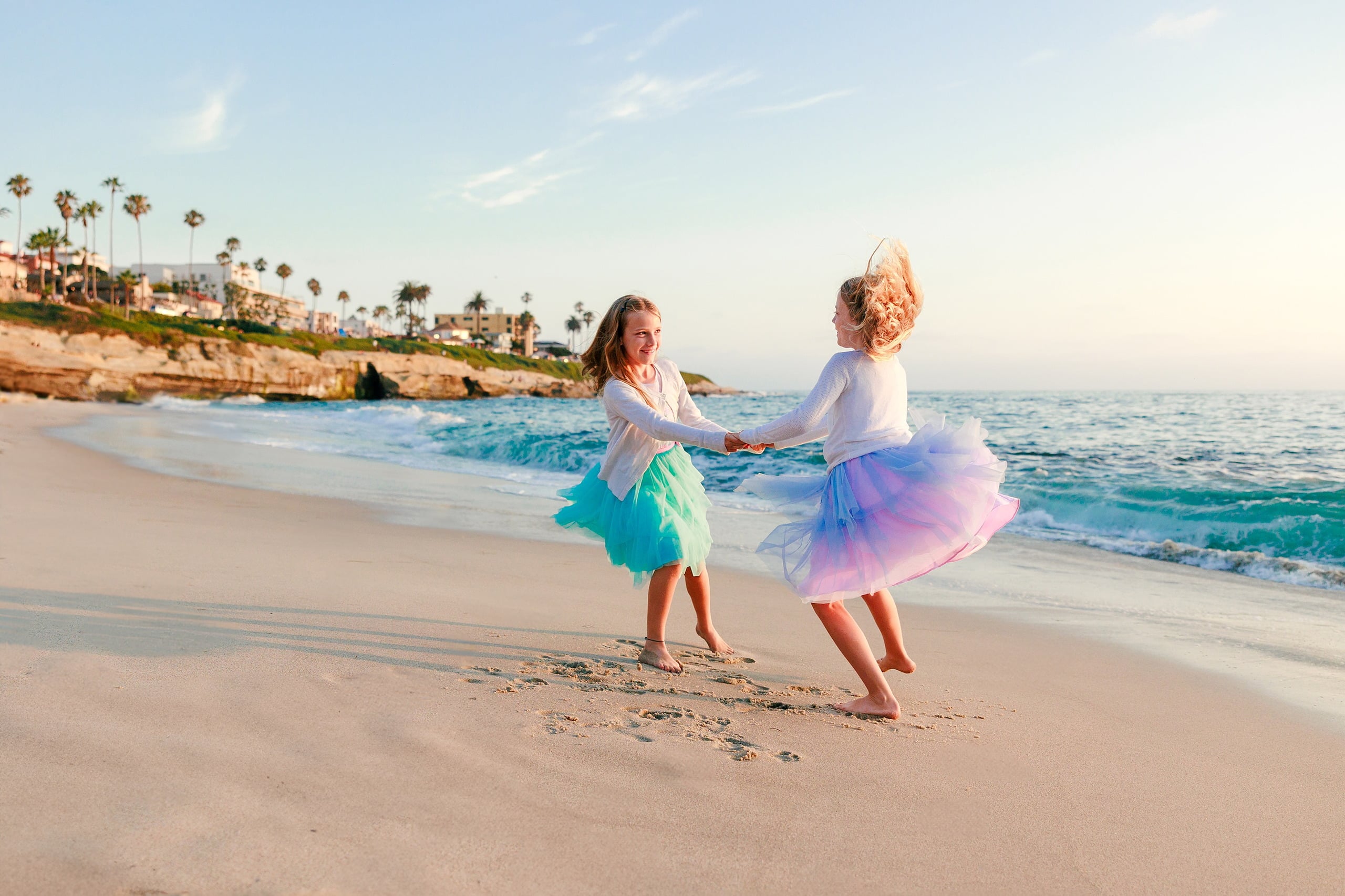 La Jolla Family Photography — 21 Two children holding hands on beach with palm tree bluff in background