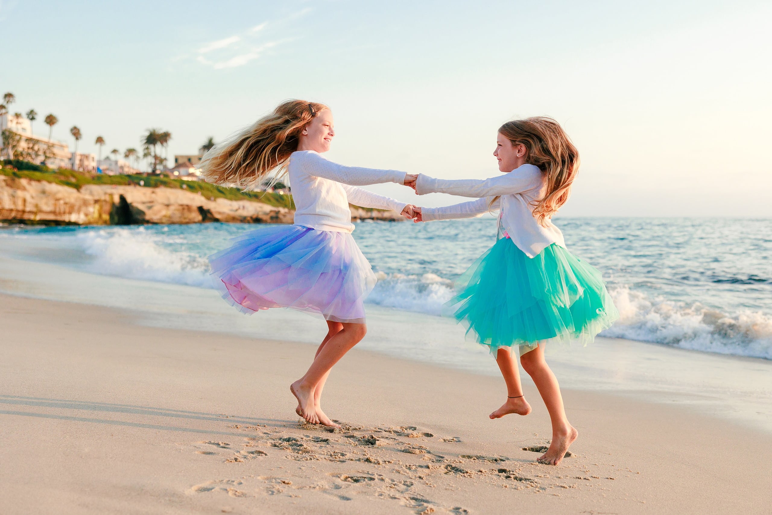 La Jolla Family Photography — 22 Two children arm in arm spinning on beach at La Jolla