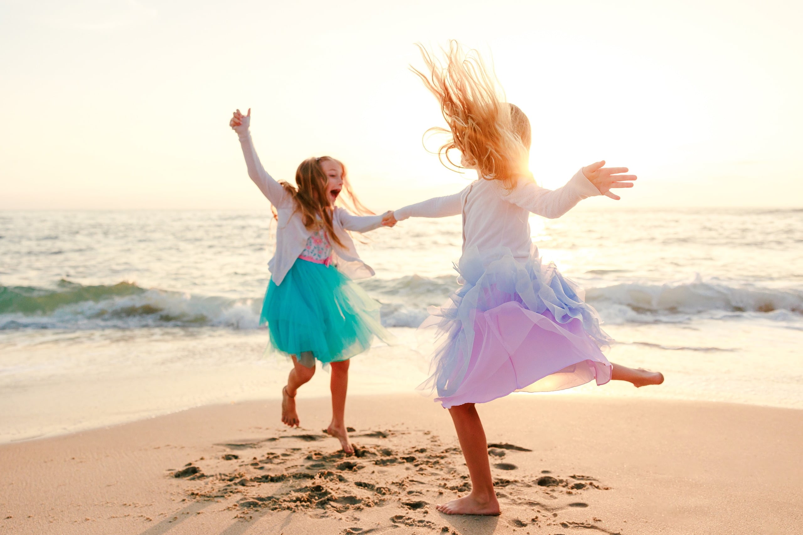 La Jolla Family Photography — 24 Two children dancing and spinning on beach with arms spread