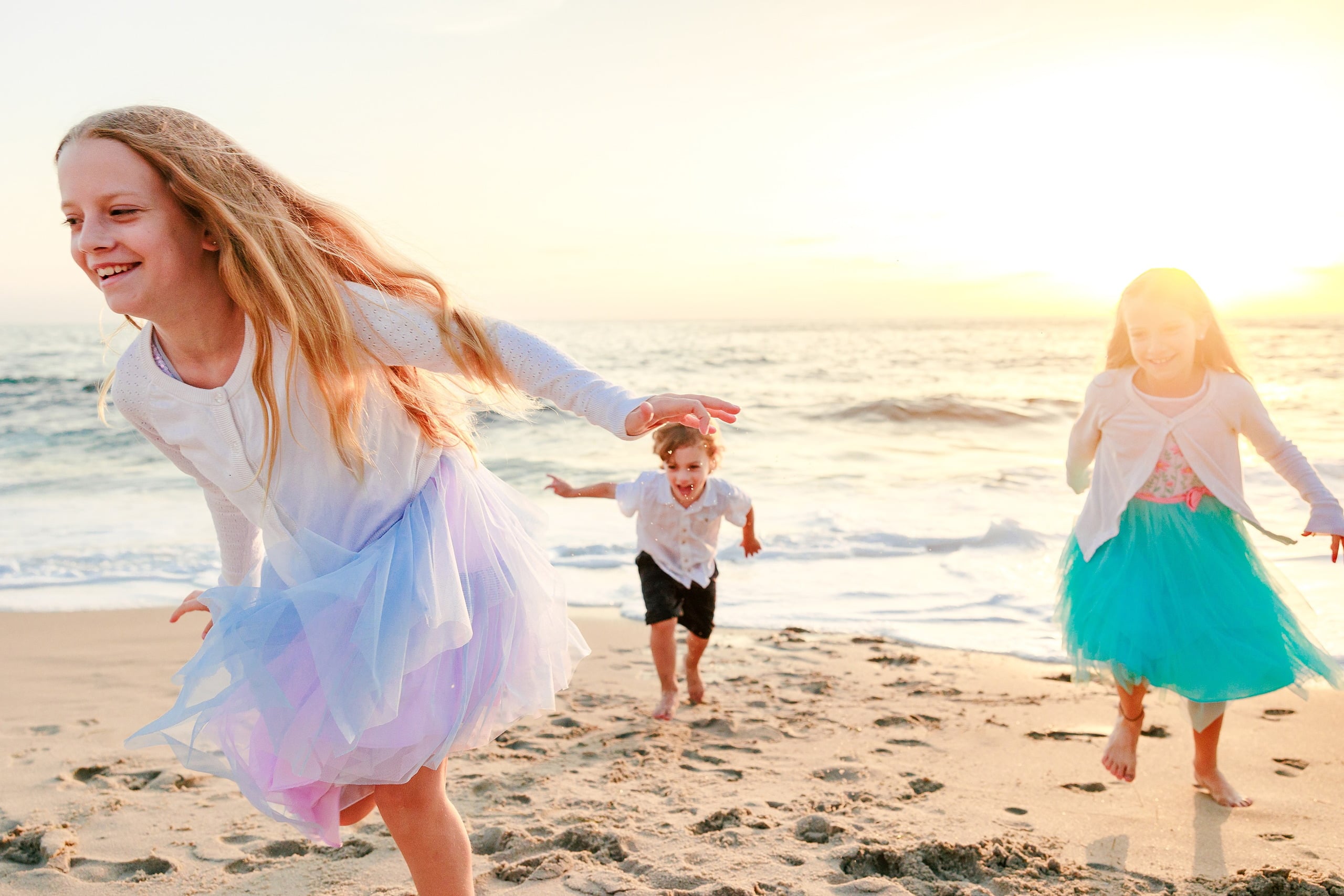 La Jolla Family Photography — 28 Older girl in purple tulle in foreground with two younger children behind on beach