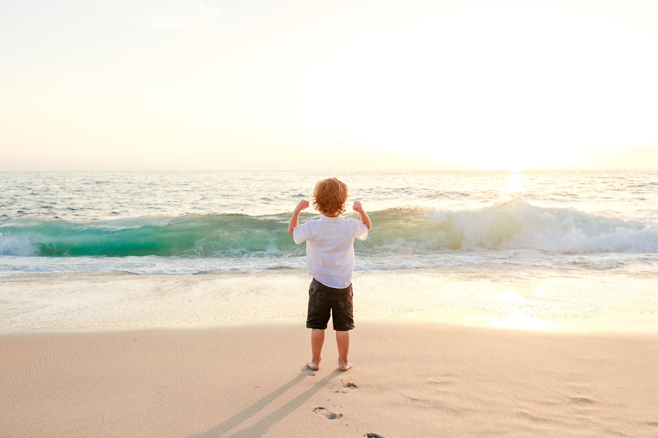 La Jolla Family Photography — 30 Toddler facing ocean with arms raised on beach