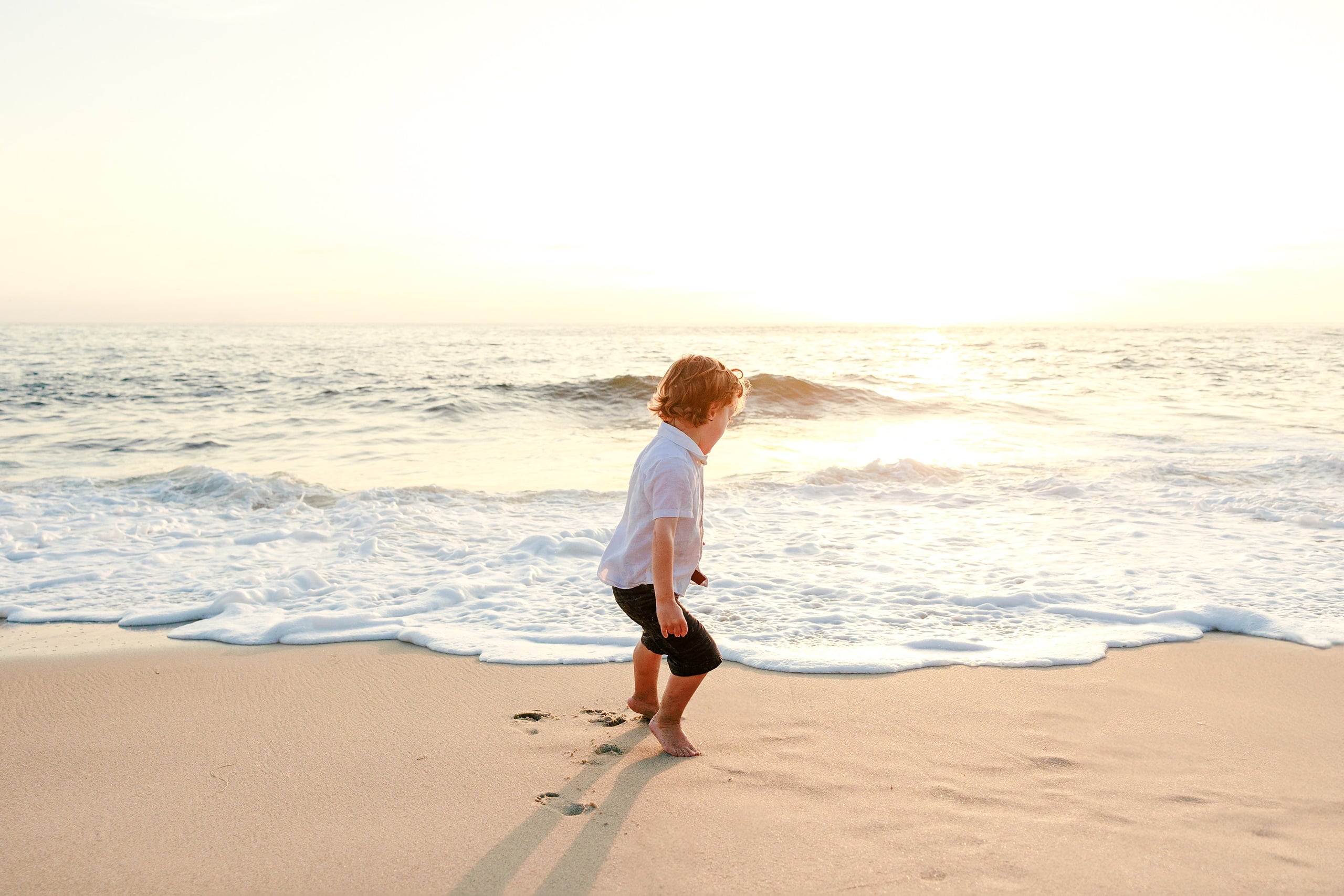 La Jolla Family Photography — 31 Toddler in white shirt running barefoot on La Jolla beach