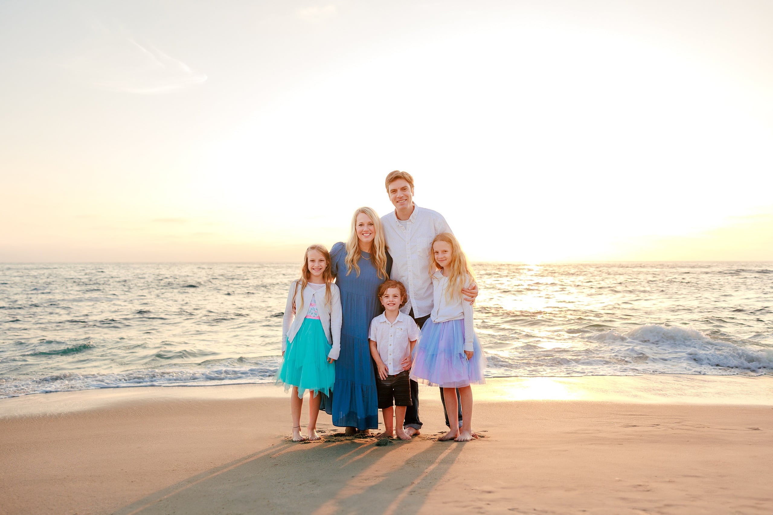 La Jolla Family Photography — 36 Family group posing on beach with woman in blue dress and children in tutus