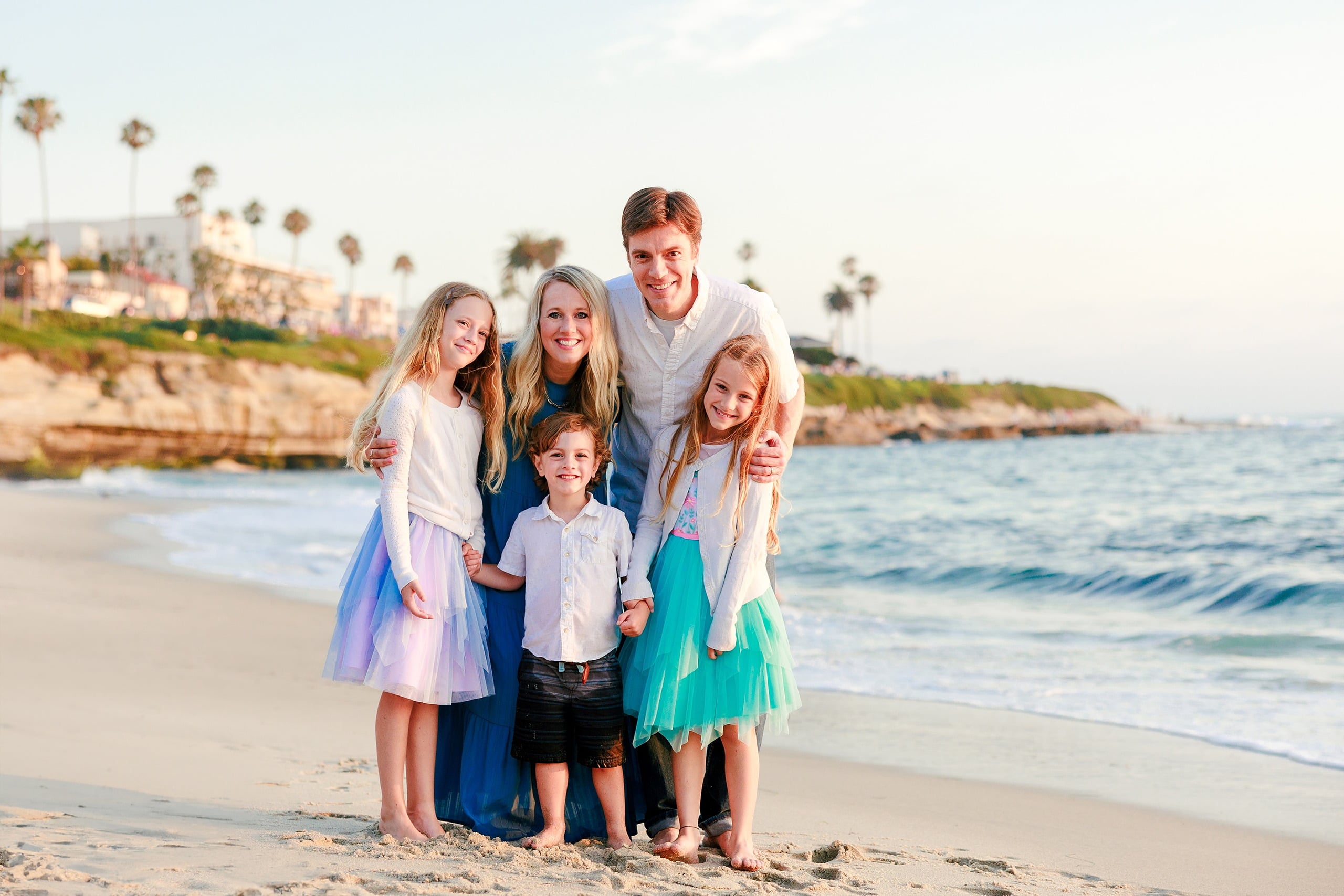La Jolla Family Photography — 37 Woman and man with four children on beach with palm tree bluff in background