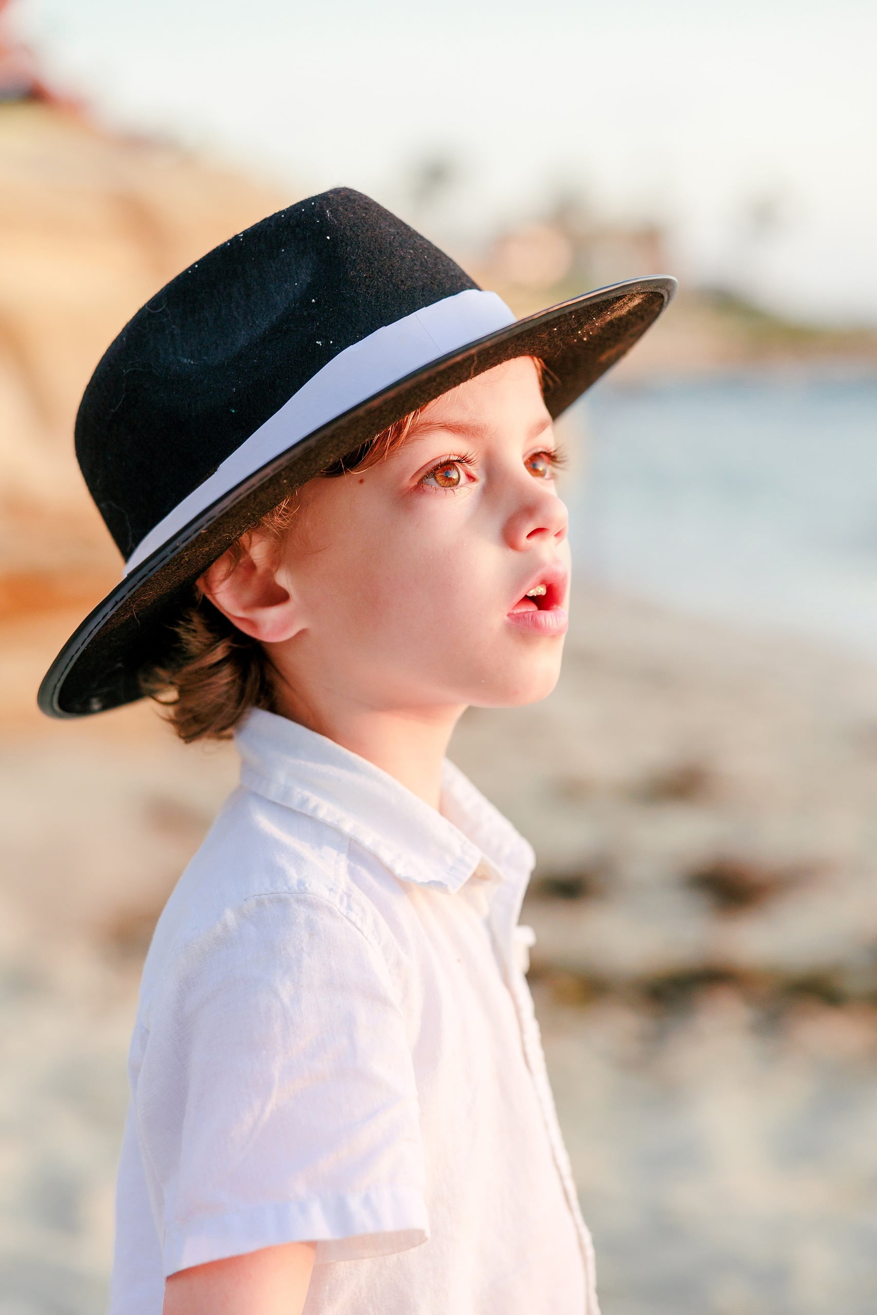 La Jolla Family Photography — 39 Close-up of young boy wearing black cowboy hat on beach