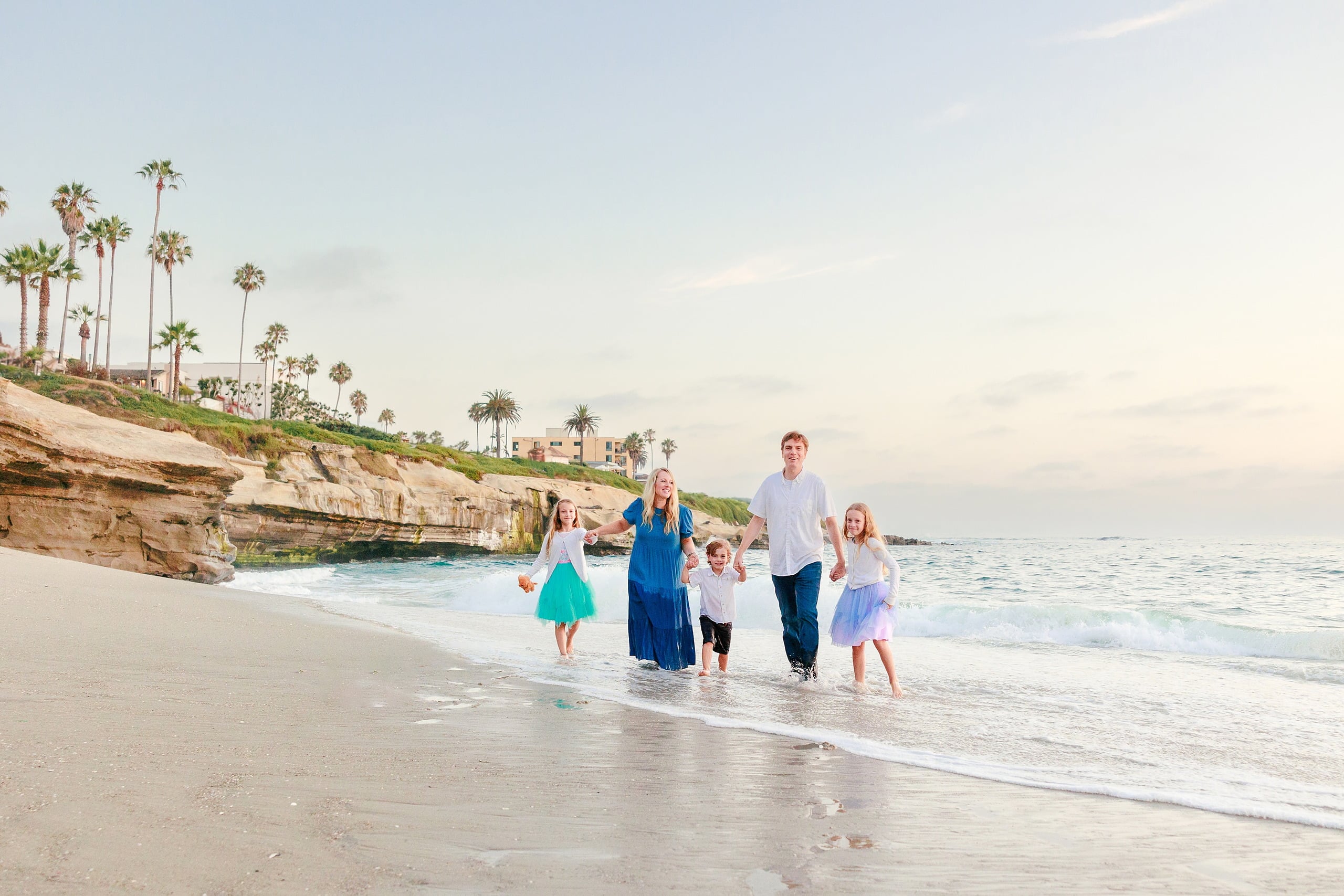 La Jolla Family Photography — 44 Family wading in shallow water on beach with children in tutus