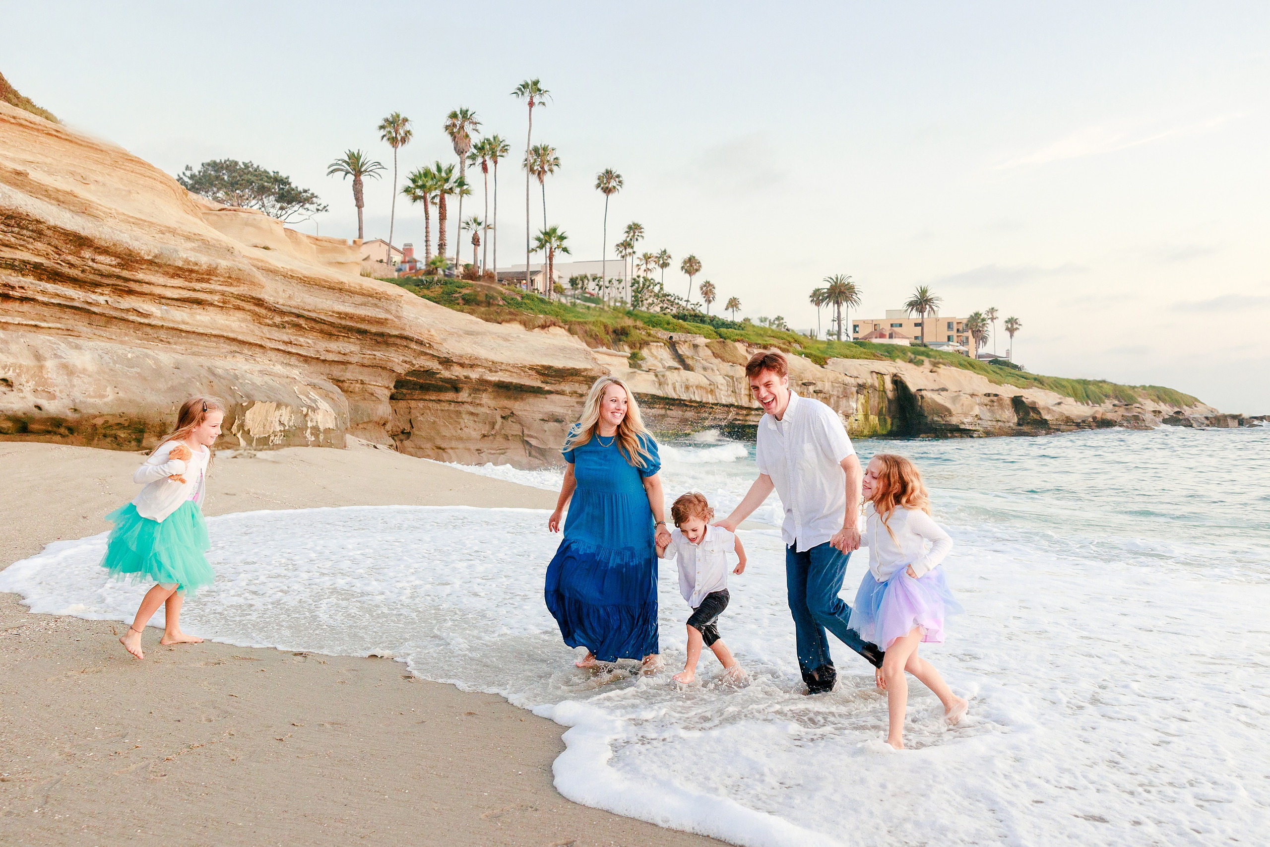 La Jolla Family Photography — 46 Family wading in ocean with woman in blue dress and children
