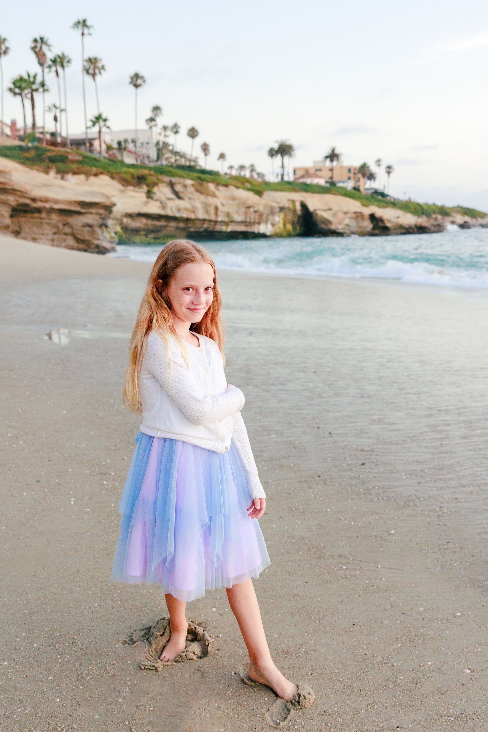 La Jolla Family Photography — 53 Girl in white long-sleeve and light purple tulle skirt on beach at La Jolla