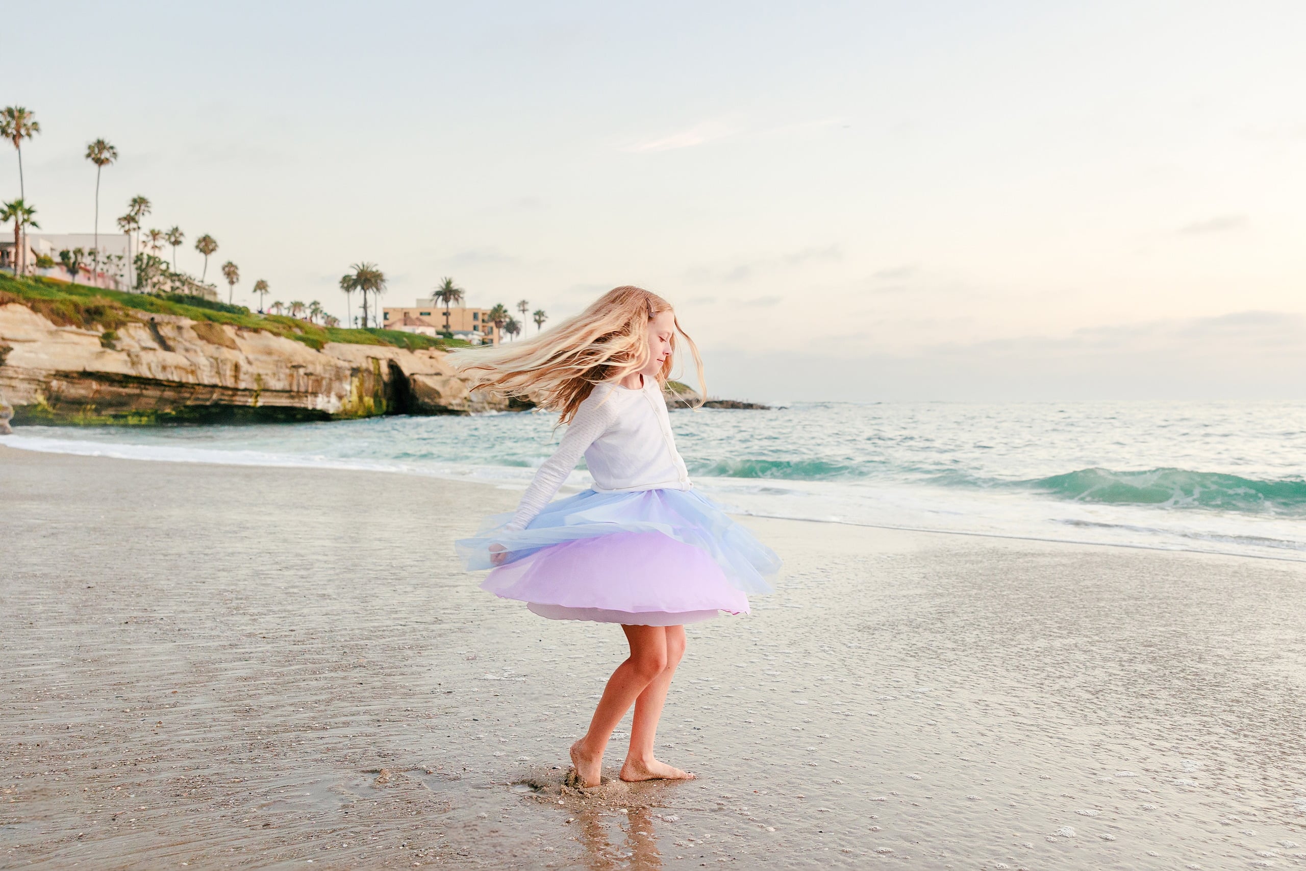 La Jolla Family Photography — 54 Girl in purple tulle skirt spinning on beach with dress flowing