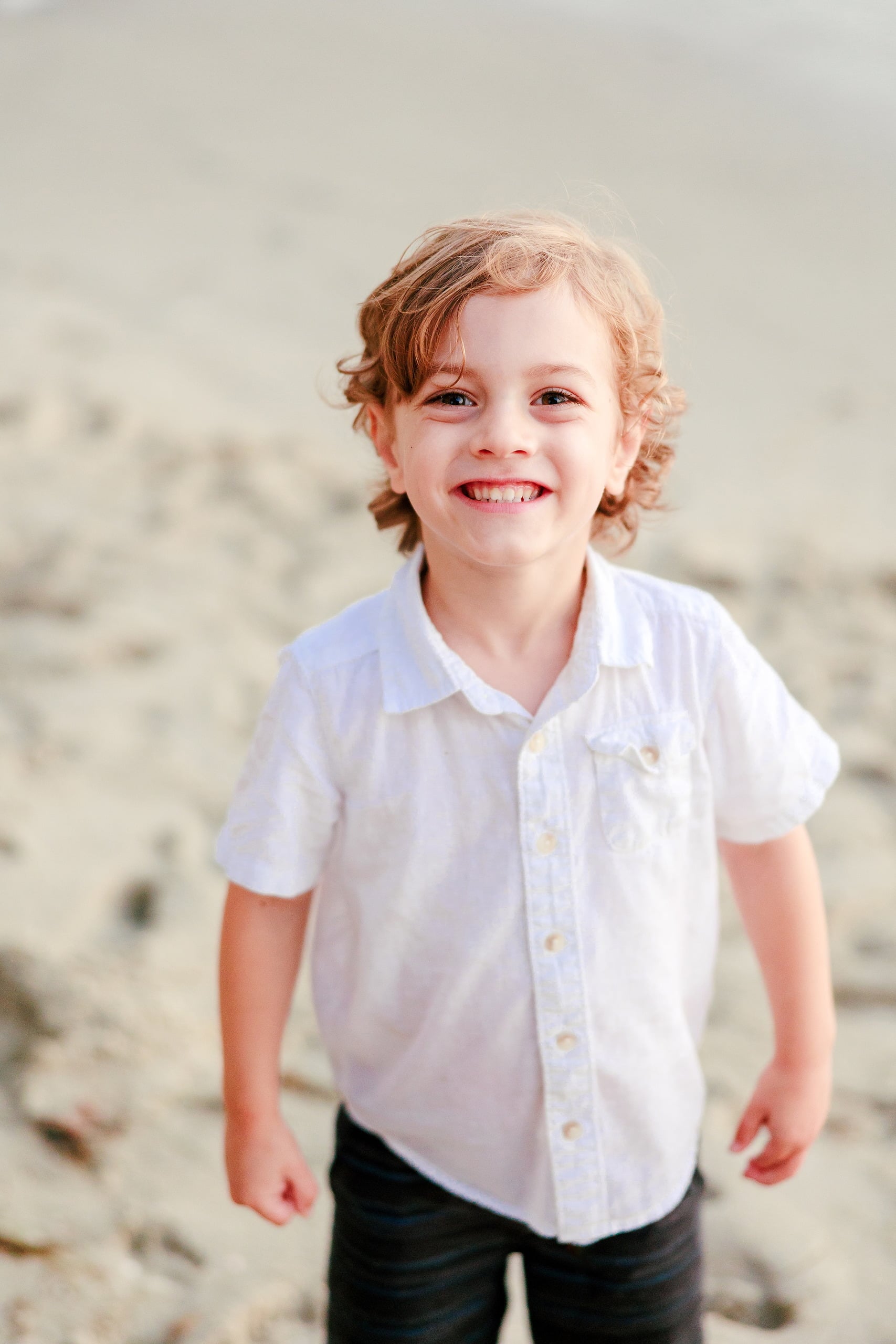 La Jolla Family Photography — 60 Close-up of toddler smiling on beach wearing white shirt