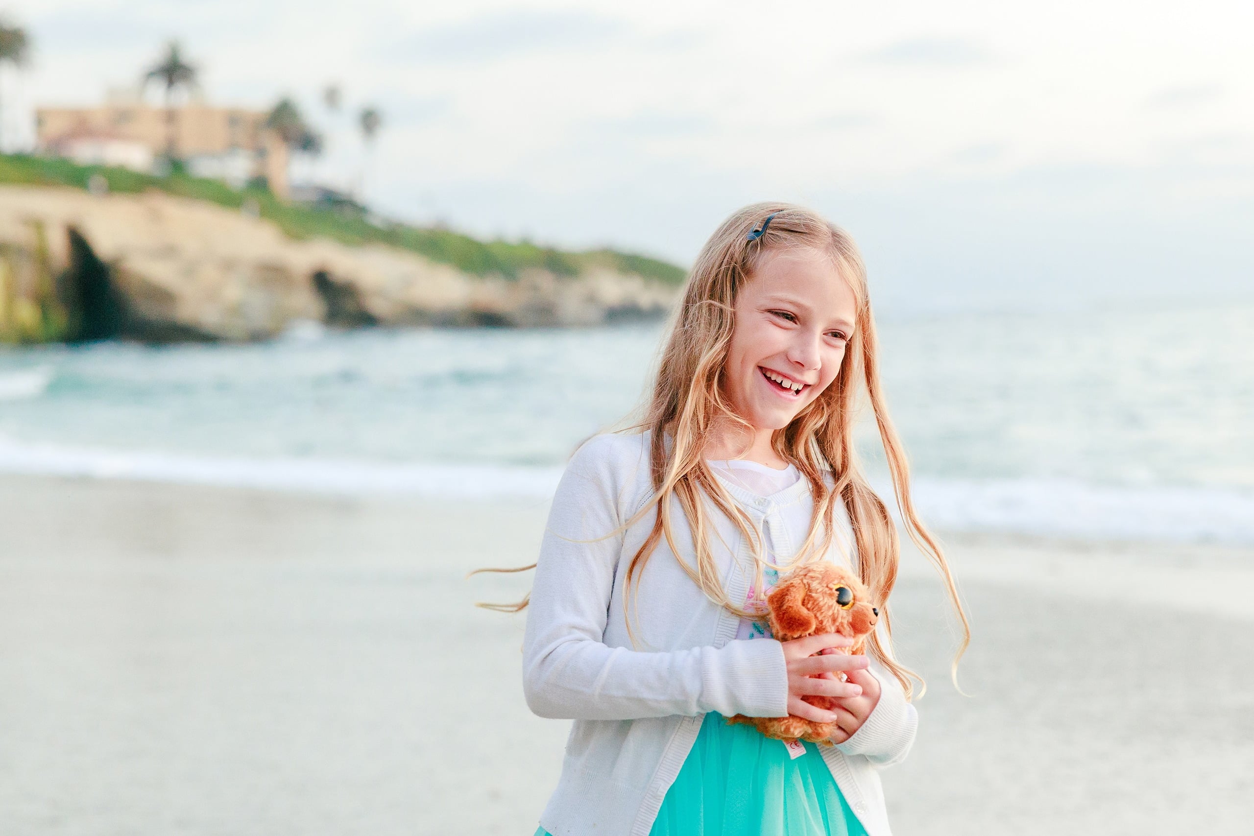 La Jolla Family Photography — 64 Girl in white long-sleeve and turquoise tulle holding starfish on beach