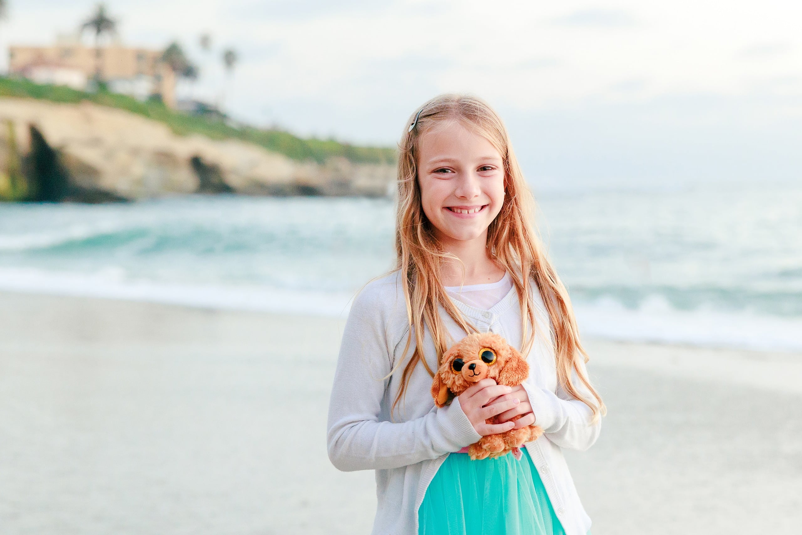 La Jolla Family Photography — 65 Girl in white and turquoise tulle holding teddy bear on beach, close-up