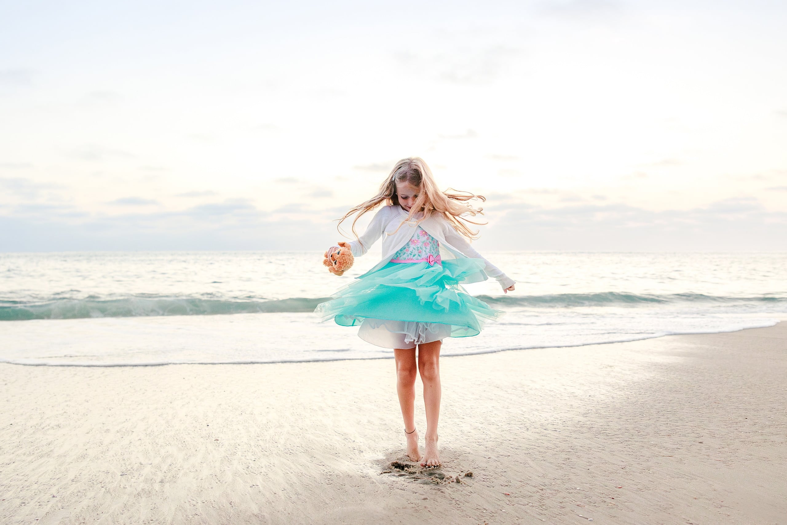 La Jolla Family Photography — 67 Girl in white and turquoise tulle spinning on beach with waves behind