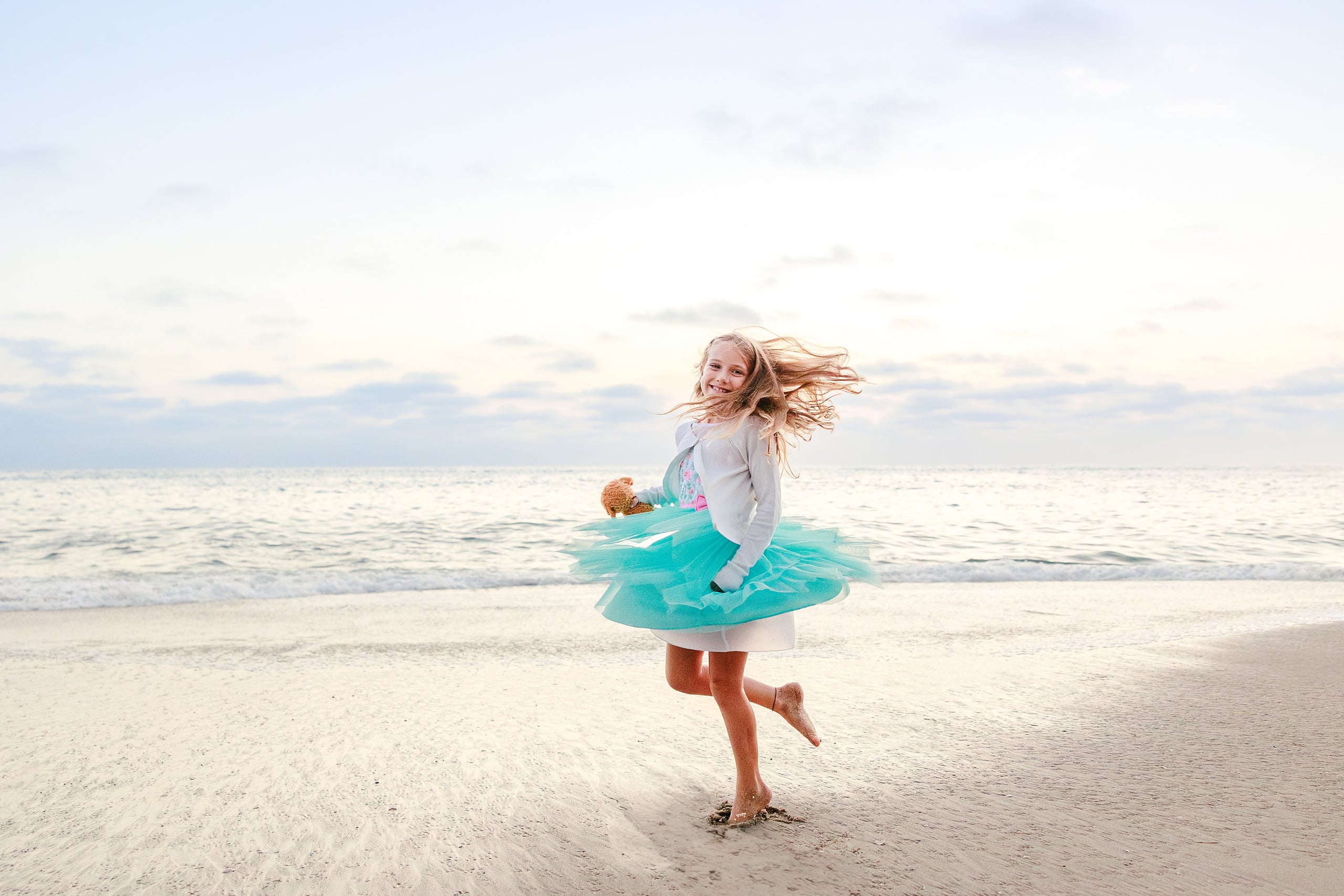 La Jolla Family Photography — 68 Girl in white long-sleeve and turquoise tulle spinning on beach