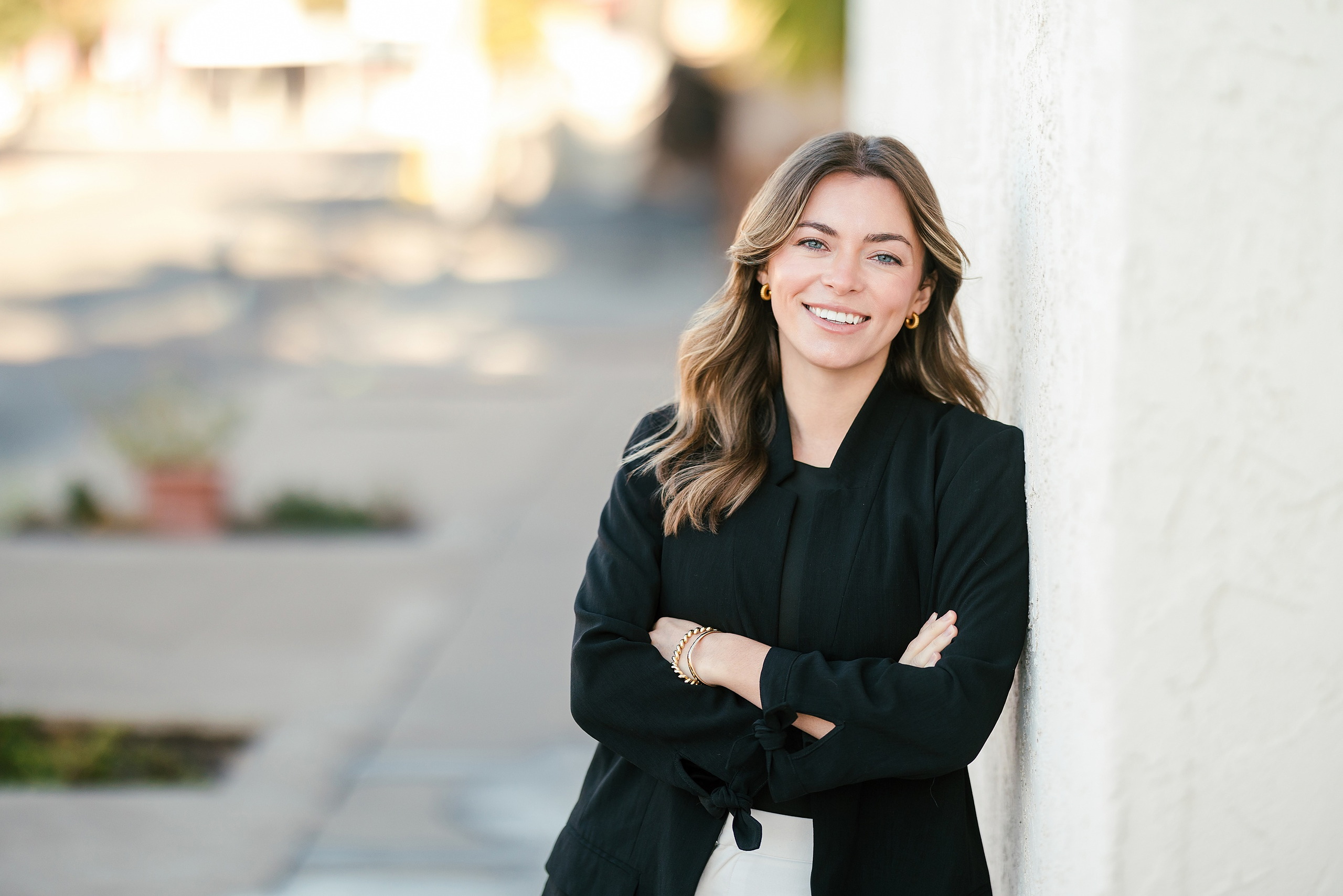Lauren Headshots in La Mesa — 06 Lauren poses with arms crossed against a white wall in warm afternoon light