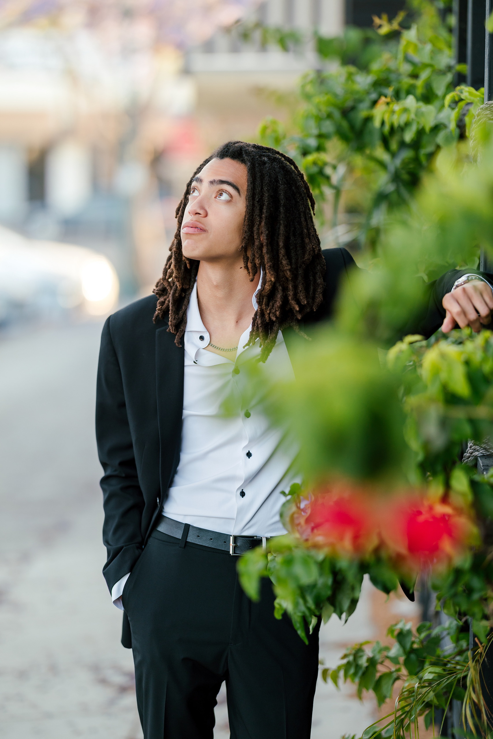 Little Italy Senior Photos — 04 Joshua looking pensively upward with ivy and plants framing scene