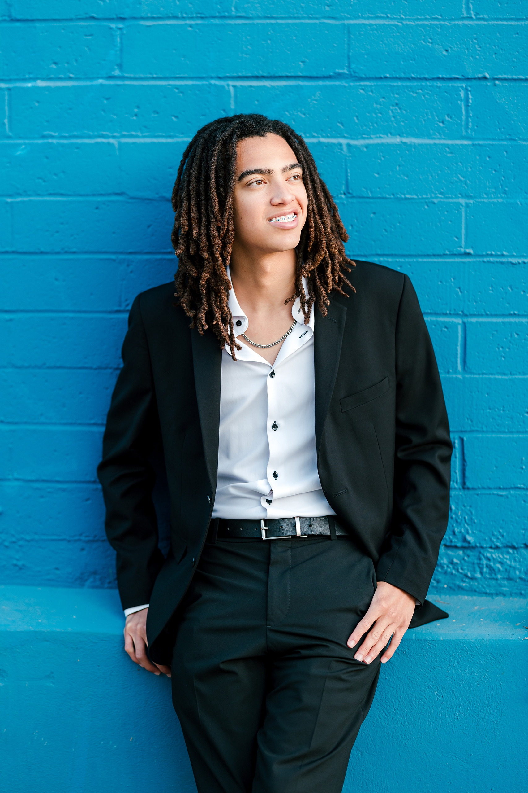 Little Italy Senior Photos — 22 Joshua walking and smiling down Little Italy street in afternoon light