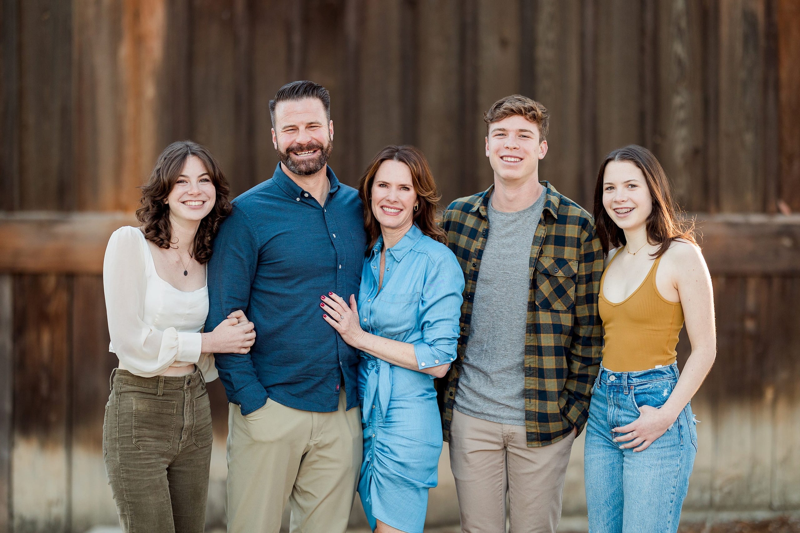 Photographer San Diego — 01 Parents and three teens standing together at wooden wall backdrop