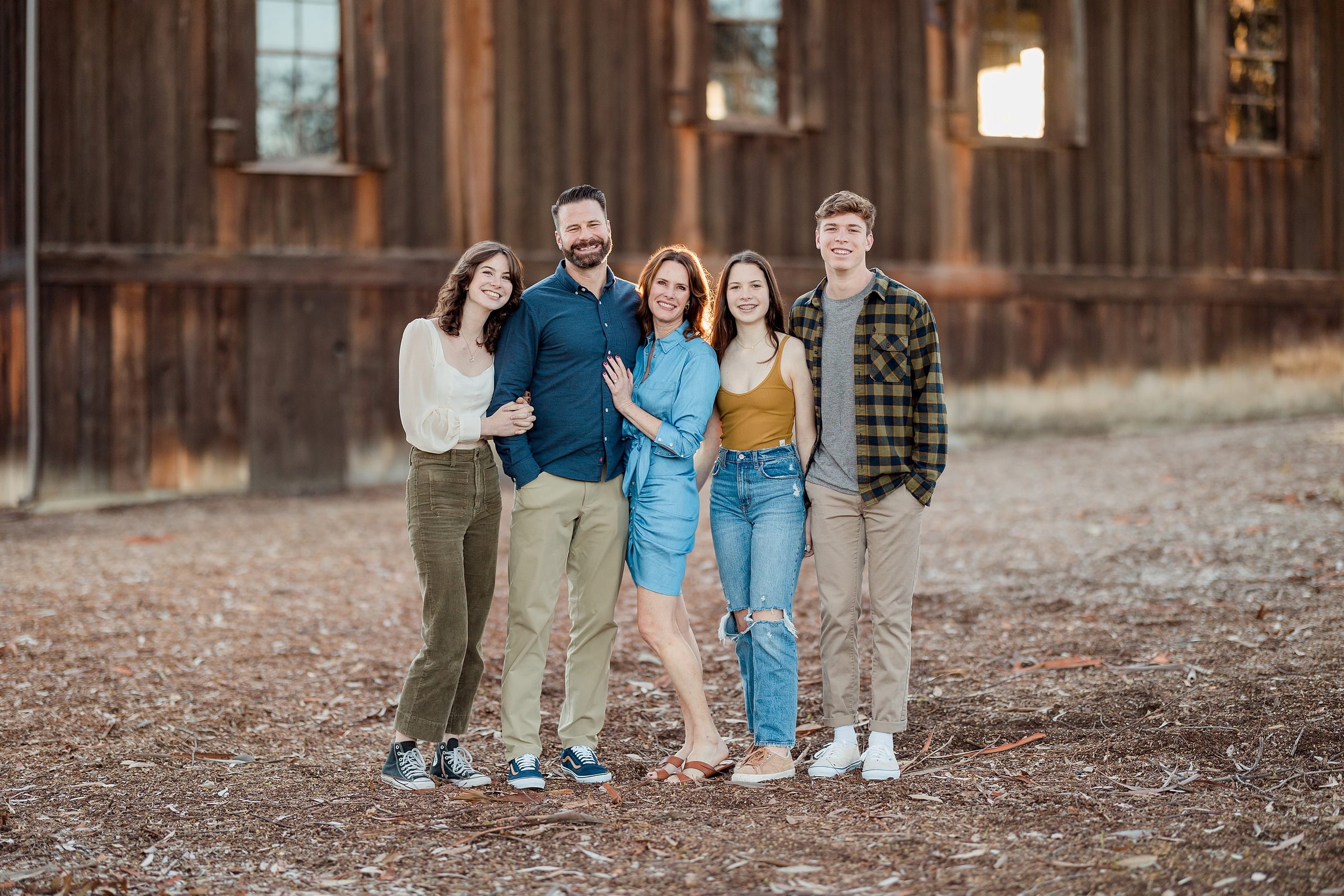 Photographer San Diego — 12 Family of five standing at rustic building with red metal roof exterior