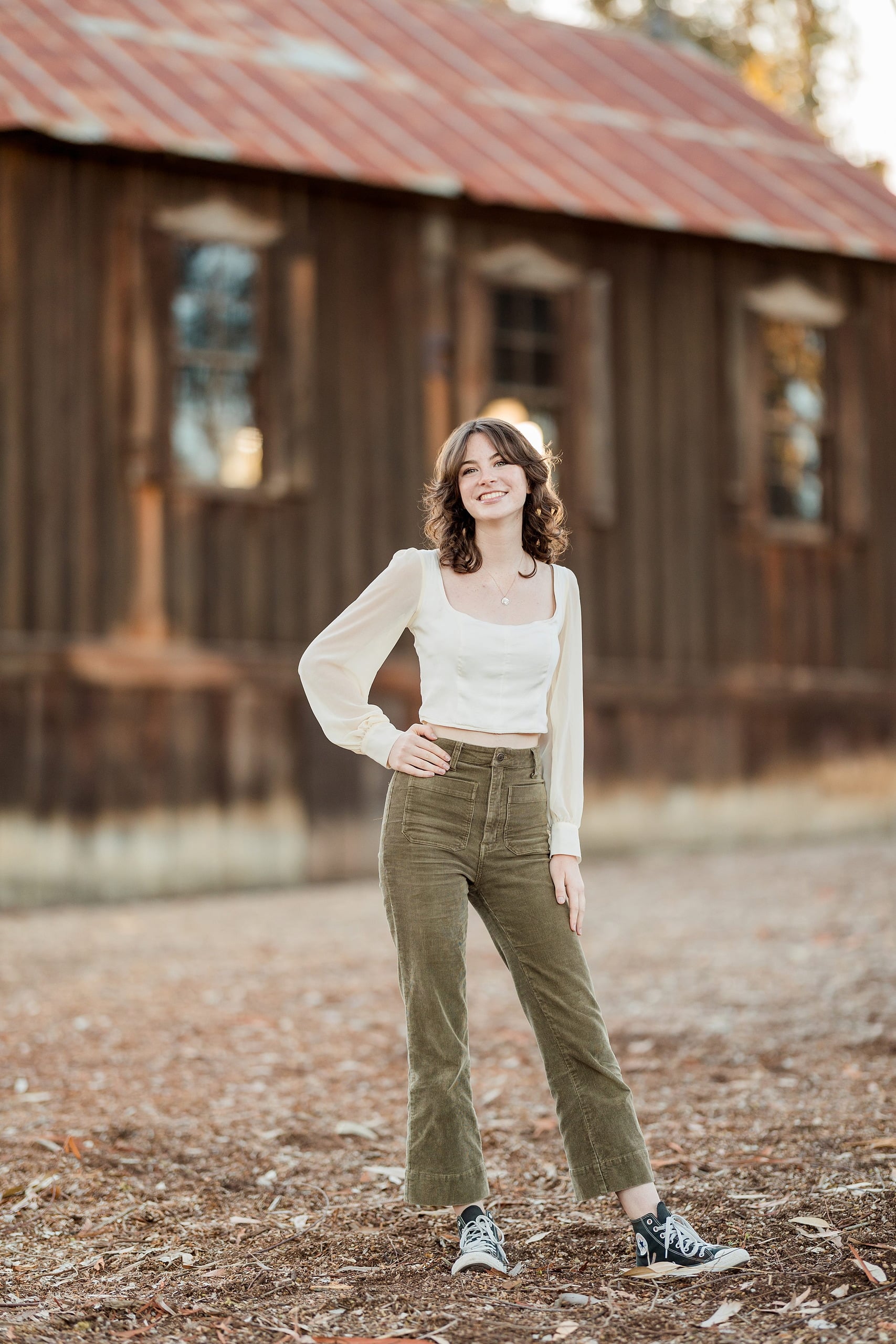 Photographer San Diego — 19 Teen girl standing at Olivenhain Town Hall in white and olive pants