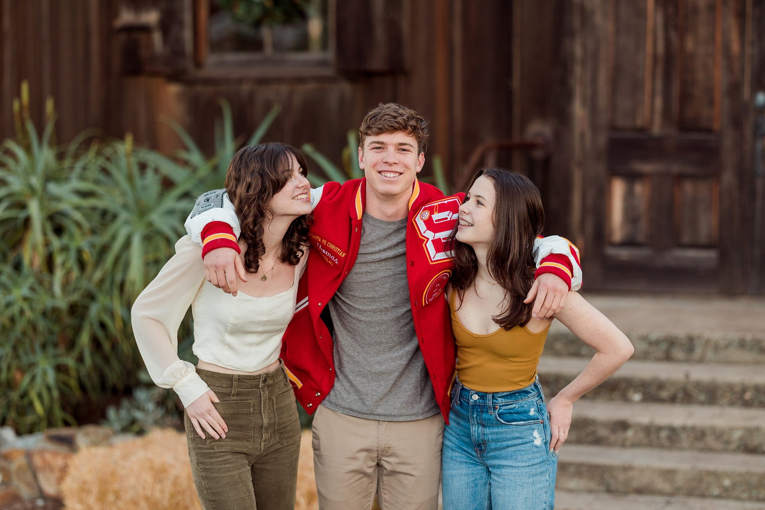 Photographer San Diego — 23 Three siblings hugging together at Town Hall entrance, boy centered