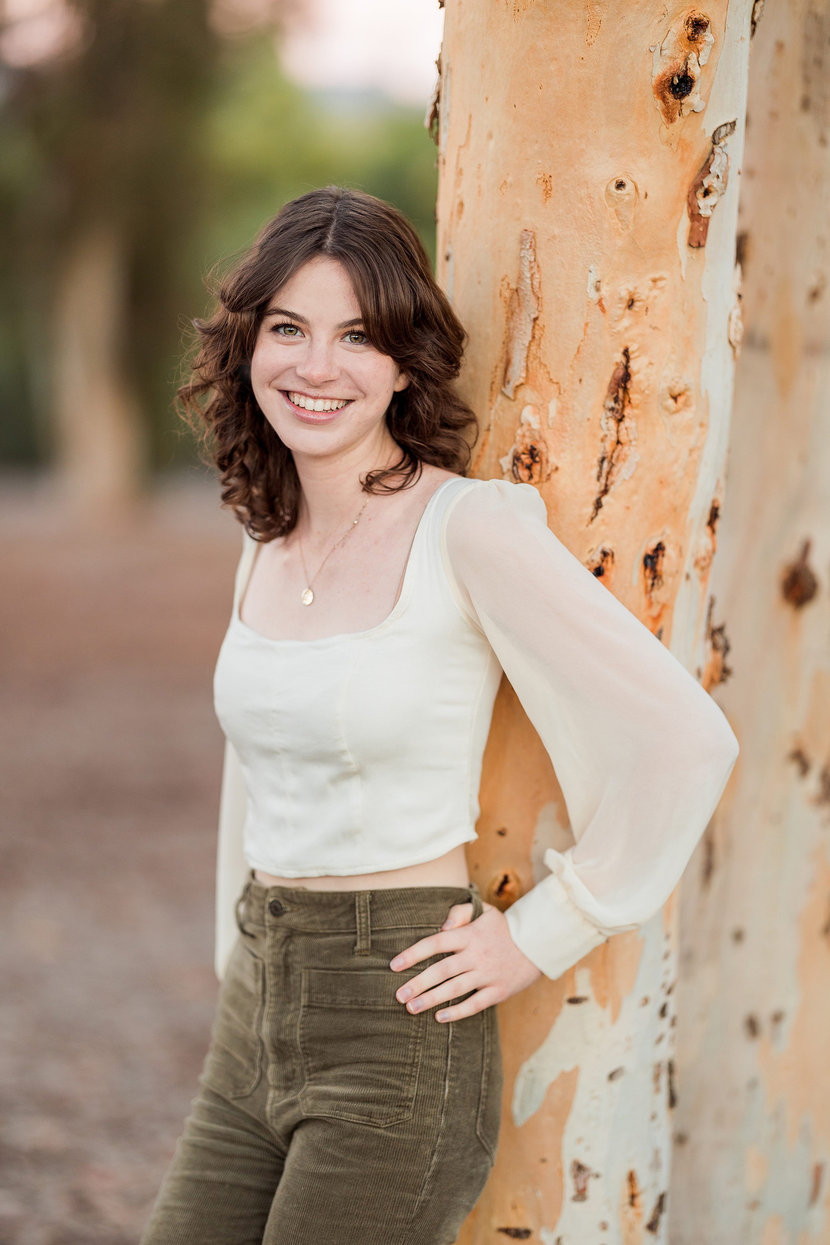 Photographer San Diego — 25 Teen girl by eucalyptus tree in cream long-sleeve, arms relaxed
