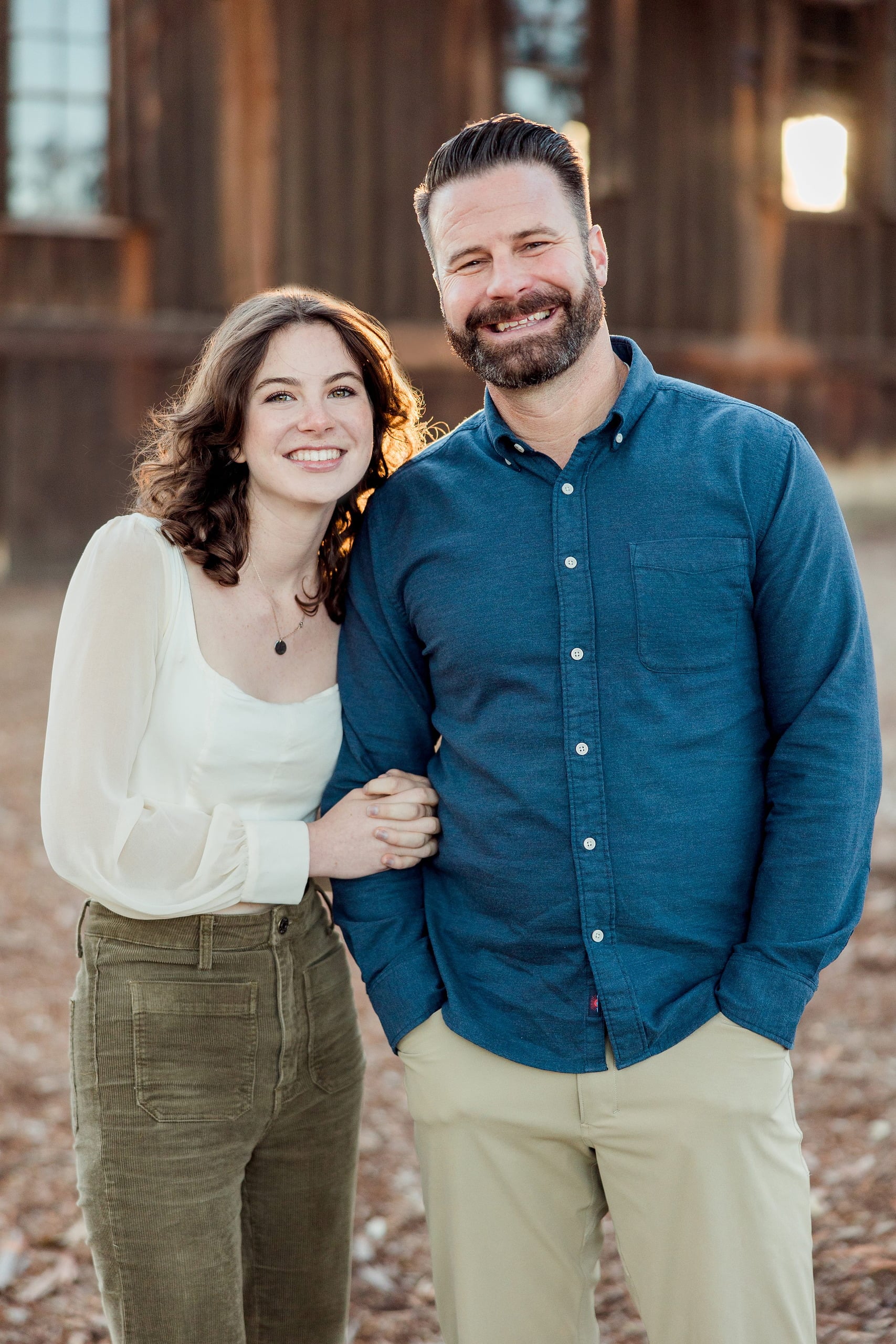 Photographer San Diego — 28 Mother and father standing together at wooden building at golden hour