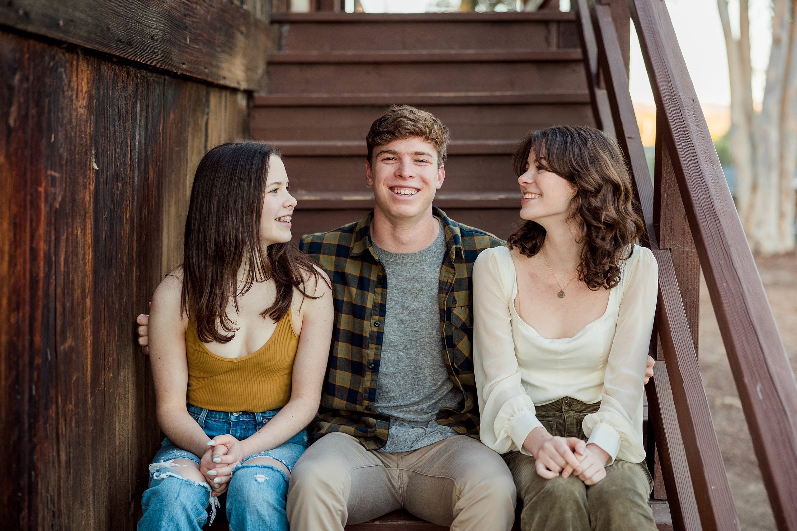 Photographer San Diego — 30 Three siblings on wooden stairs, side-by-side seating arrangement