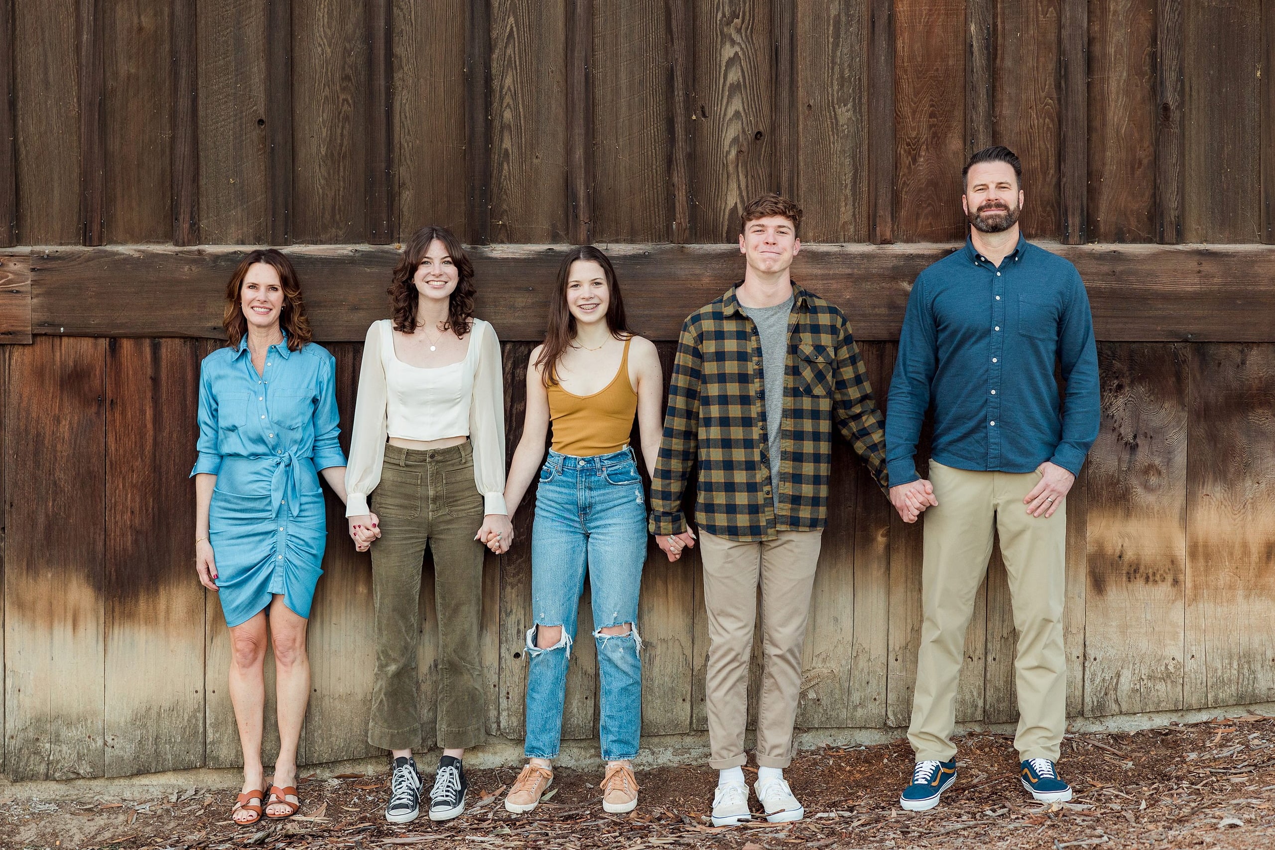 Photographer San Diego — 32 Family of five holding hands in line in front of wooden wall