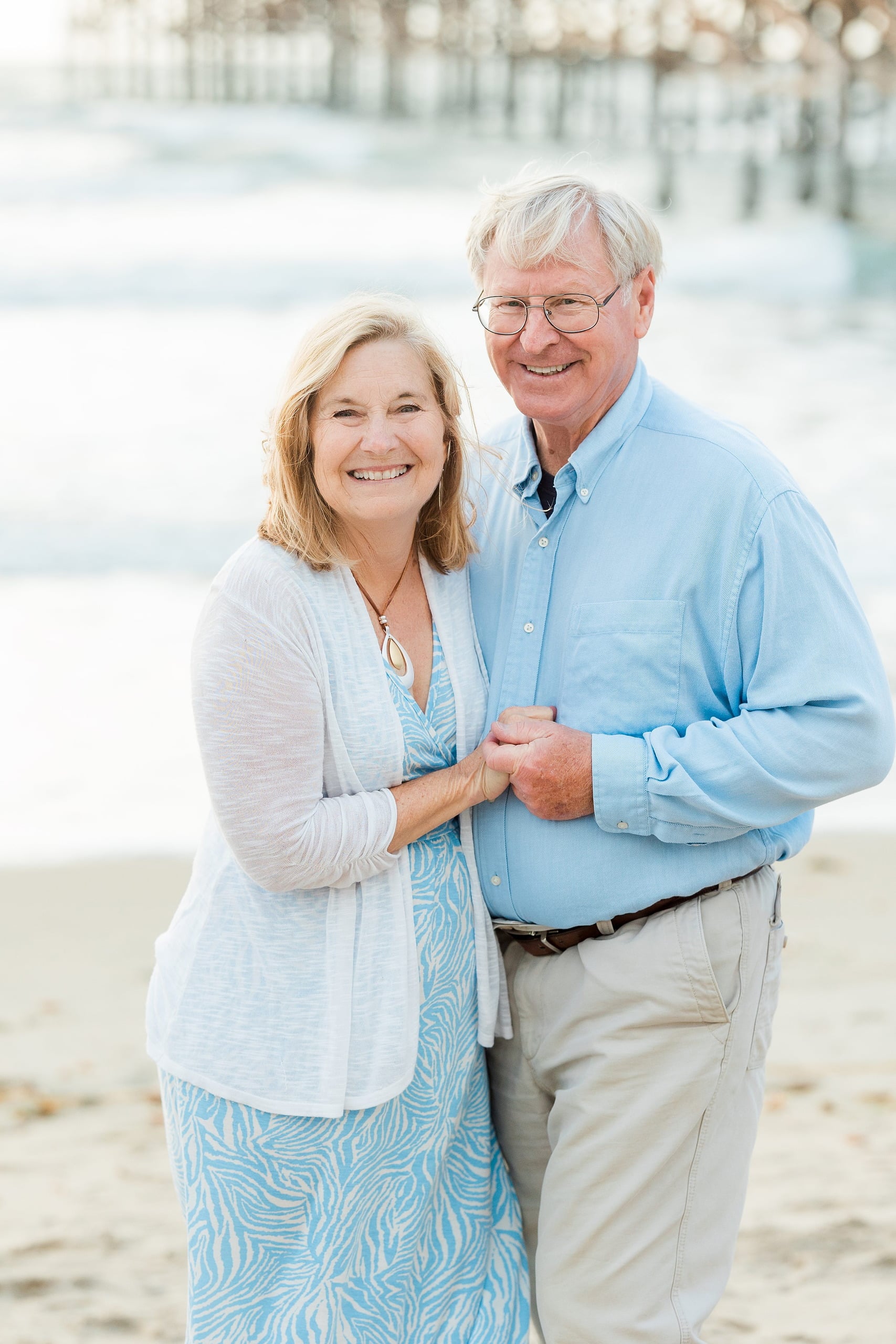 Rainy Day Beach Photo Session — 12 Grandmother and grandfather stand smiling with two children between them on the beach