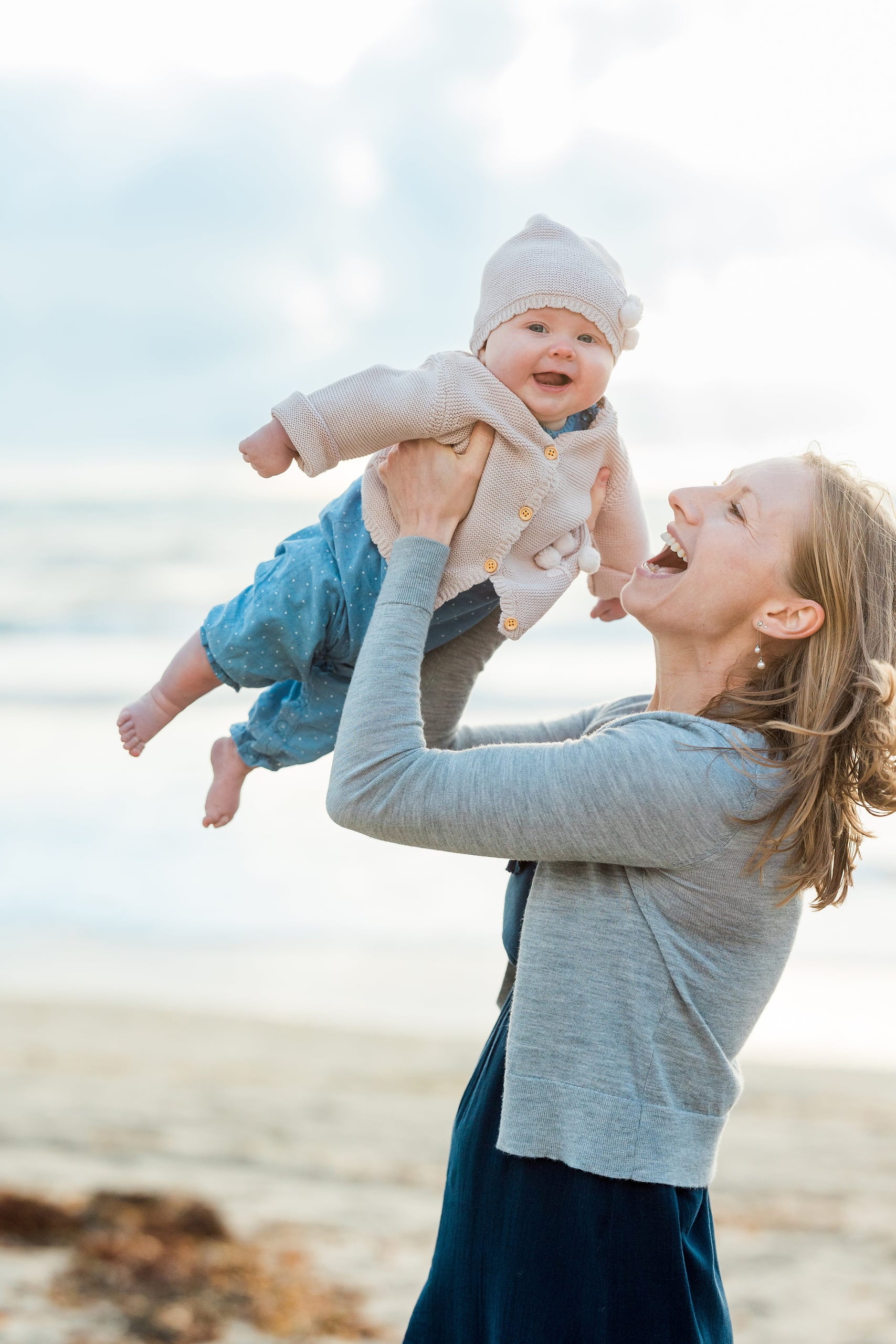 Rainy Day Beach Photo Session — 14 Woman holds toddler and another child while standing on sand at Crystal Pier