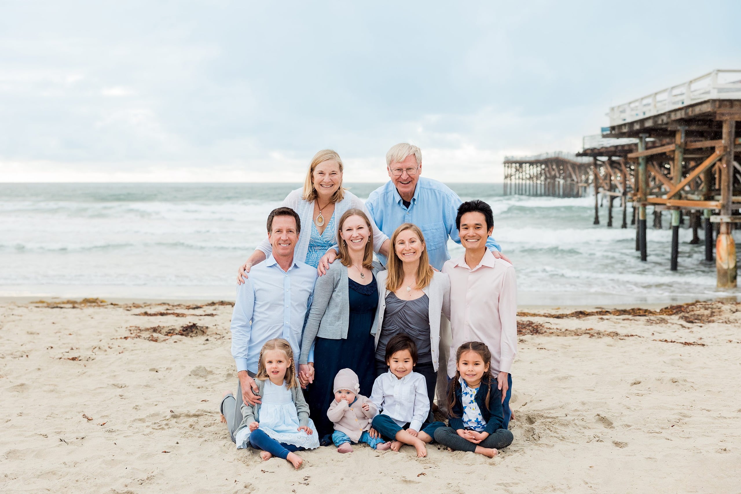 Rainy Day Beach Photo Session — 23 Multi-generational family group of nine standing together on the beach at Crystal Pier