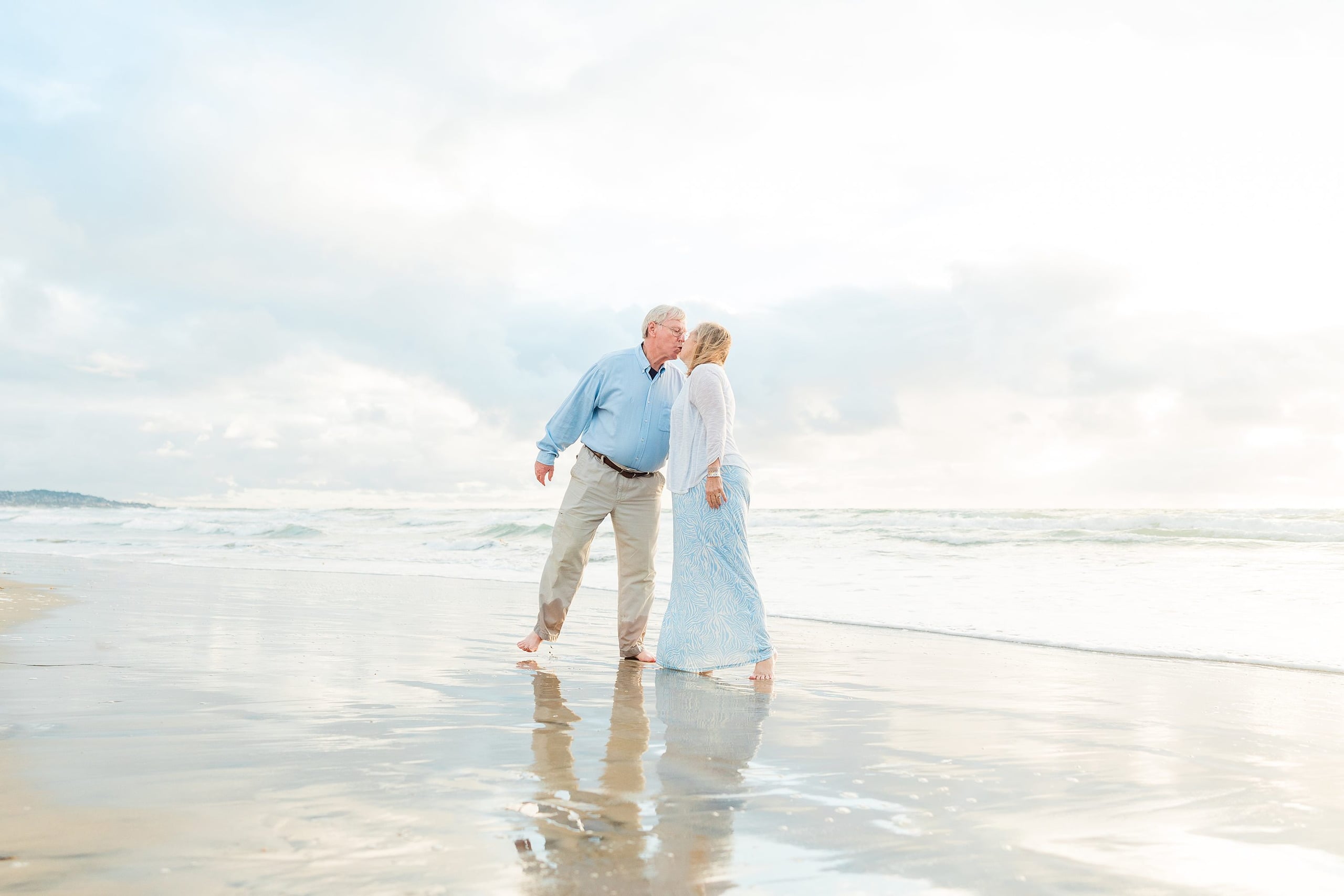 Rainy Day Beach Photo Session — 32 Man walks holding child's hand with woman and two children beside them in sand