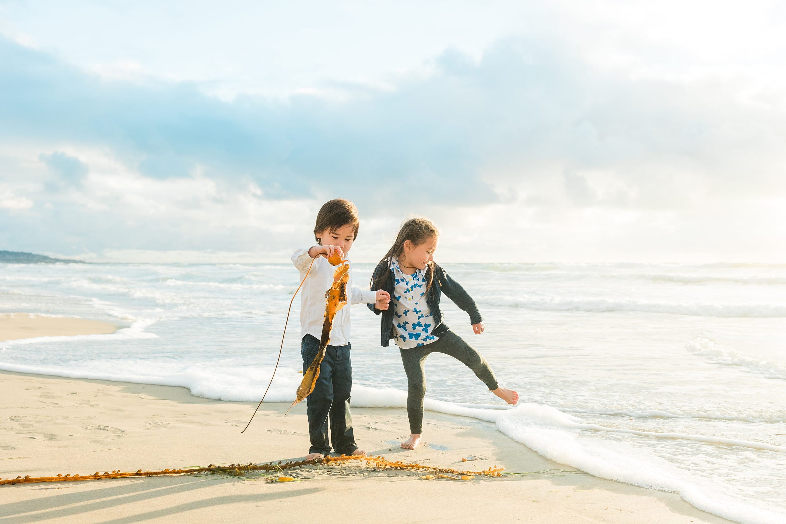 Rainy Day Beach Photo Session — 36 Two children play together on the wet sand with seaweed near Crystal Pier