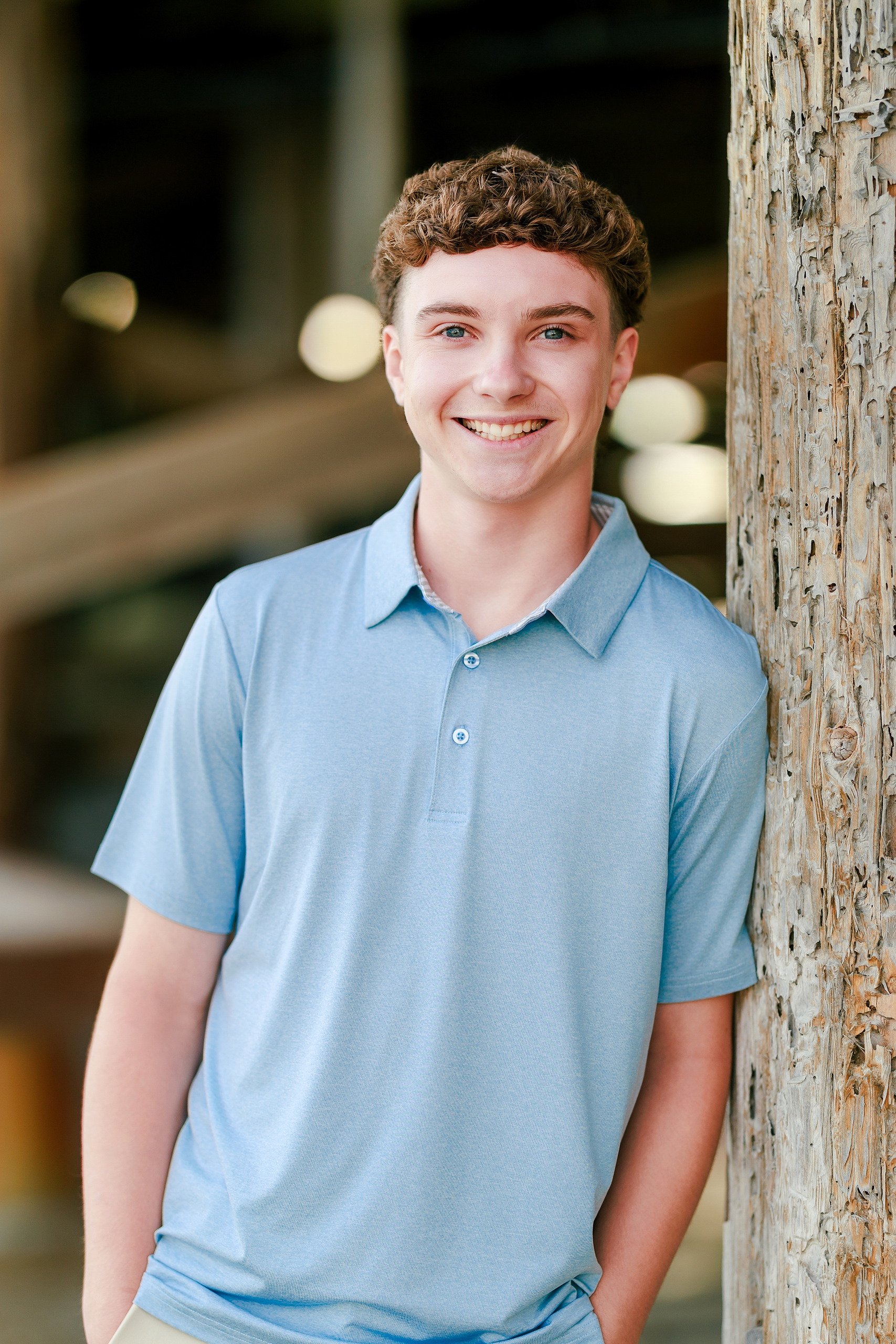 San Diego Beach Family Photos — 02 Teen in light blue polo standing by weathered pier pilings
