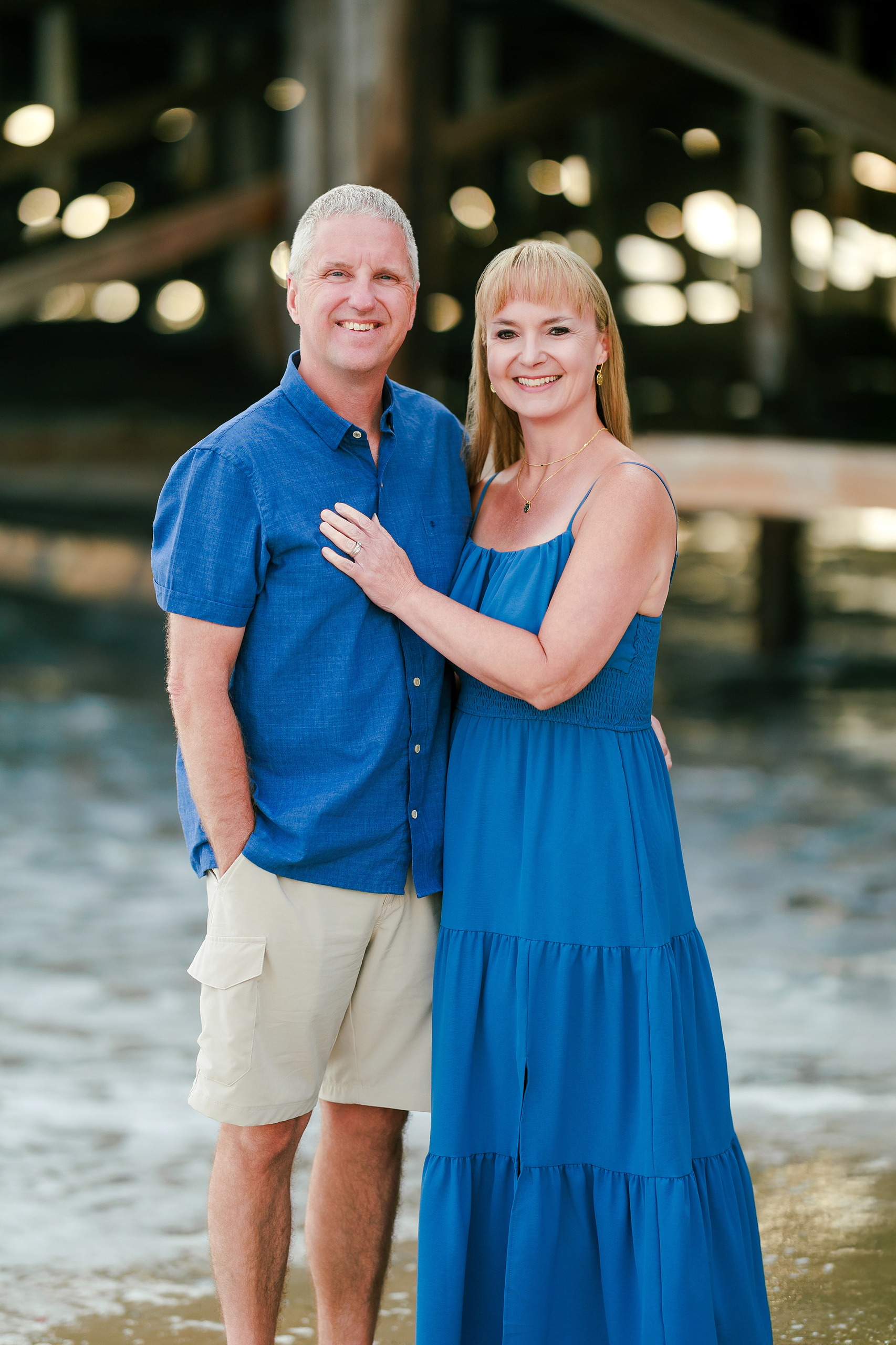 San Diego Beach Family Photos — 08 Teen boy in blue shirt embracing woman in blue dress on sand