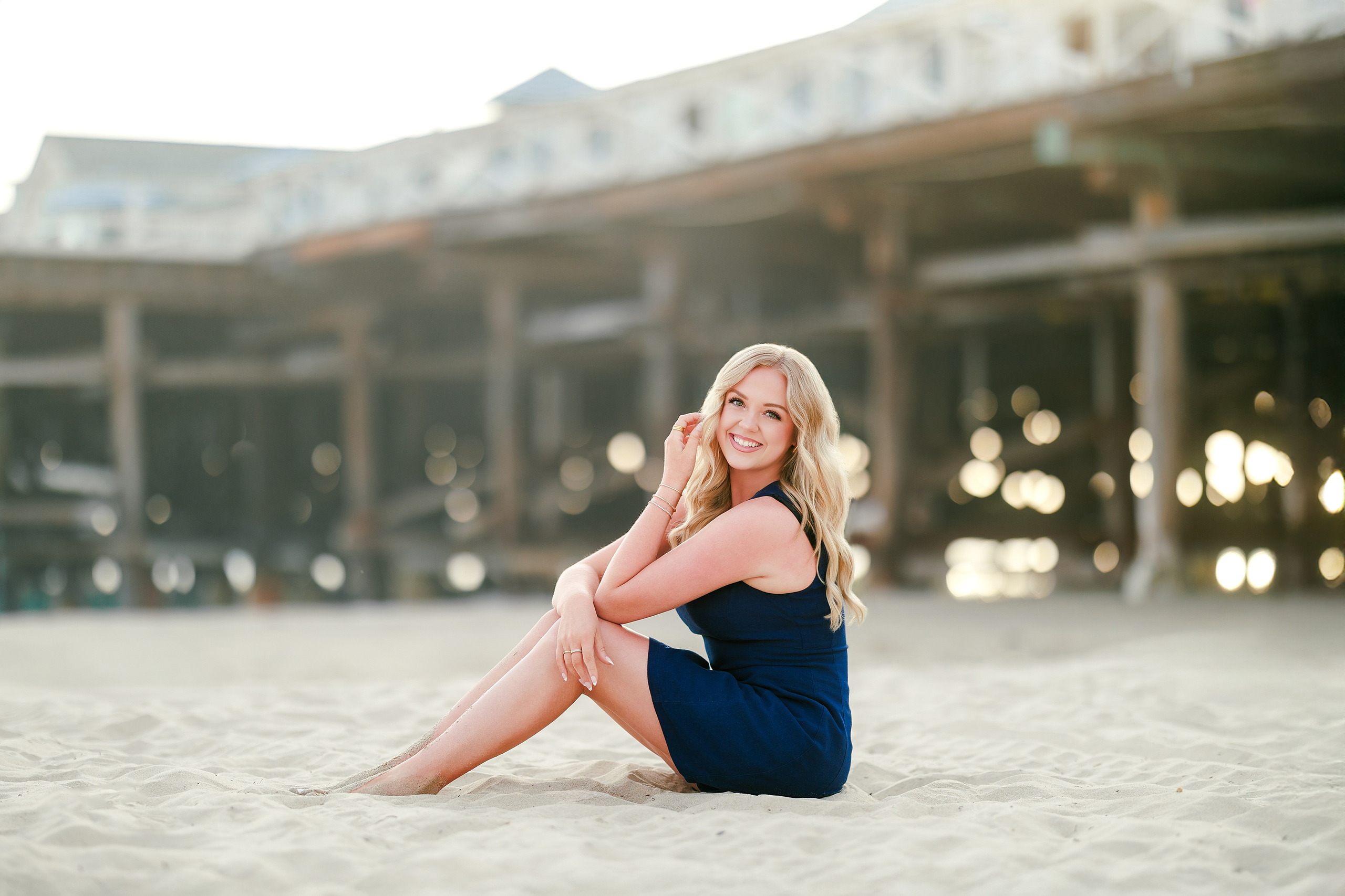 San Diego Beach Family Photos — 11 Woman in blue dress leaning against weathered pier support